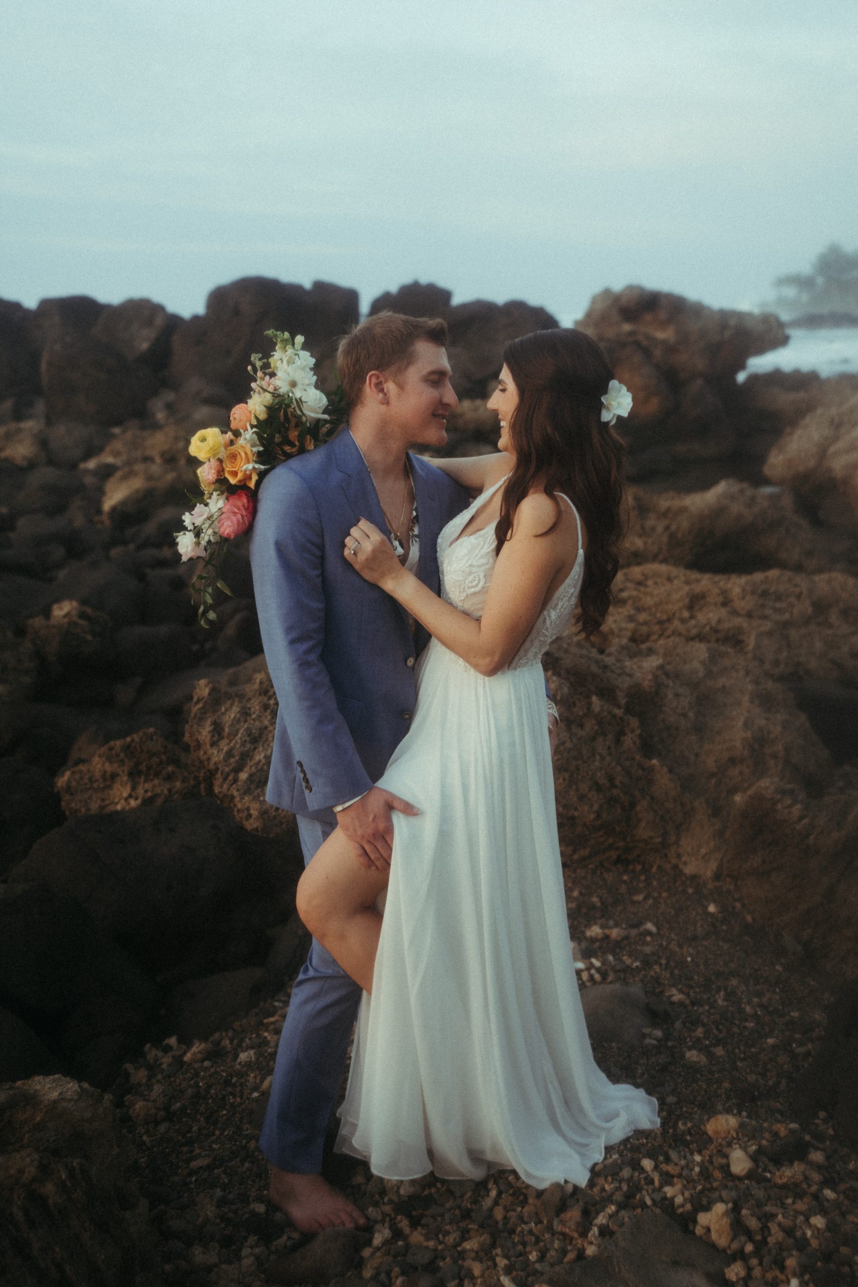Intimate newlywed portraits on rocky beach on Oahu's North Shore captured by Masha Sakhno Photo.