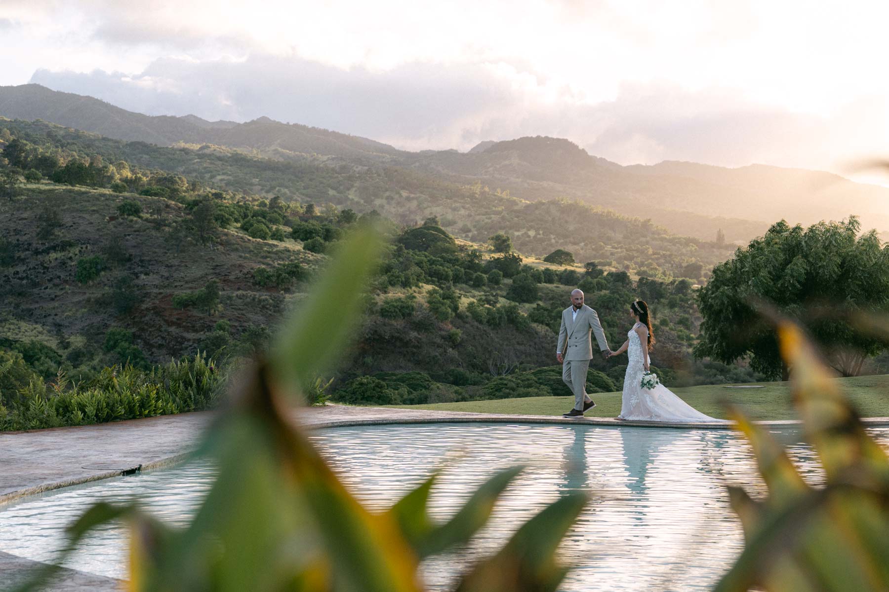 Kaala Vista:  couple walks along the pool during their Ka'ala Vista Oahu wedding.