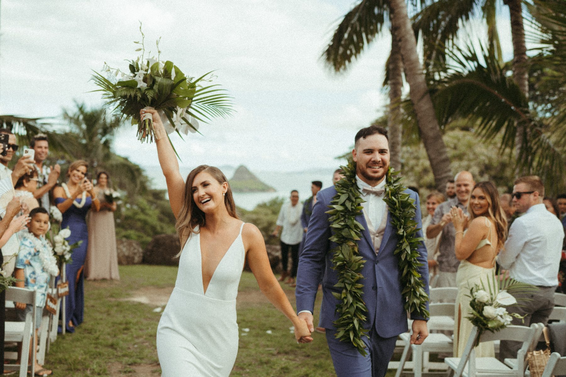 Newlyweds walking down the aisle at Paliku Gardens at Kualoa Ranch captured by Masha Sakhno Photo.