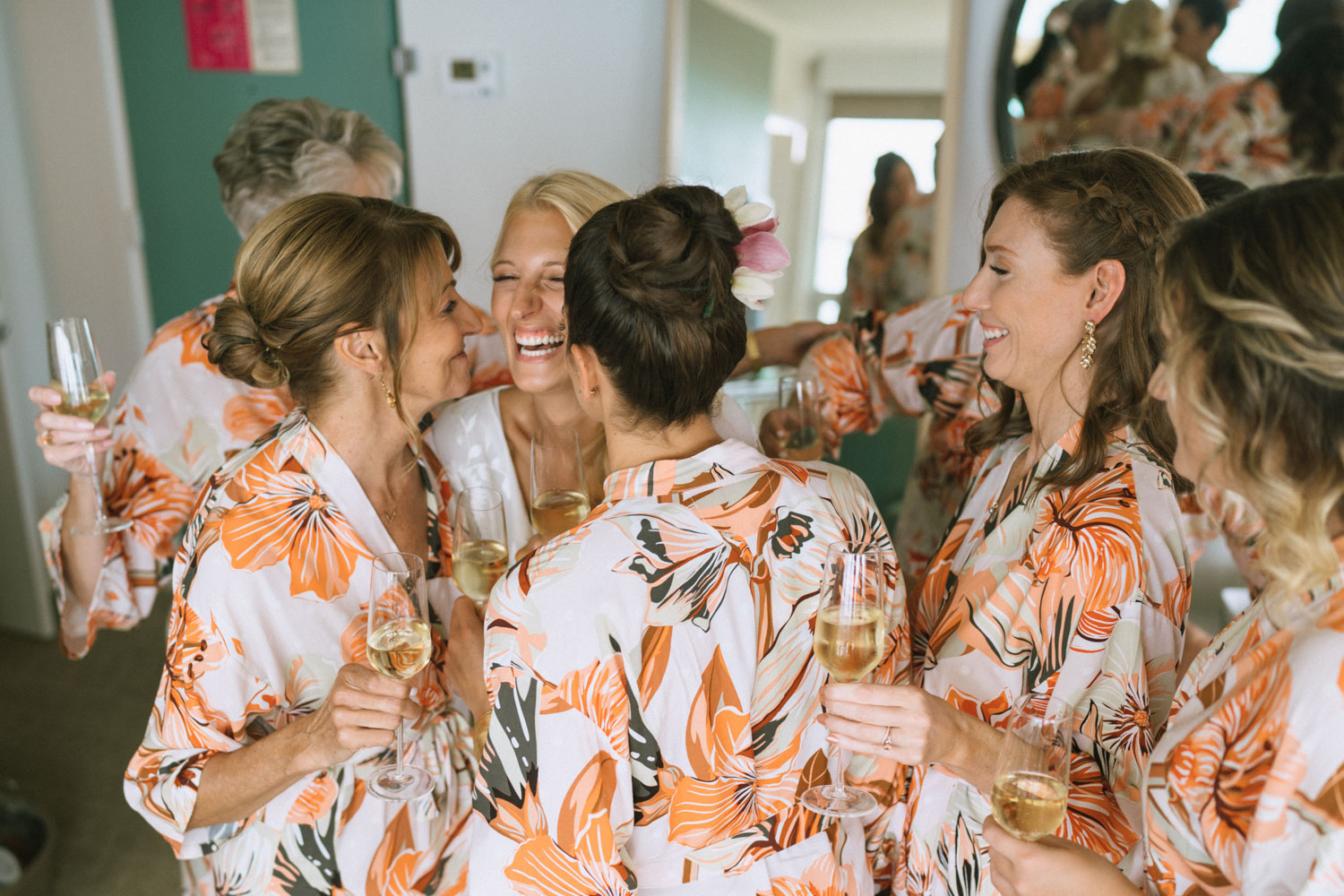 Bride and bridesmaids are in matching robes at the Queen Kapiolani hotel in Oahu.