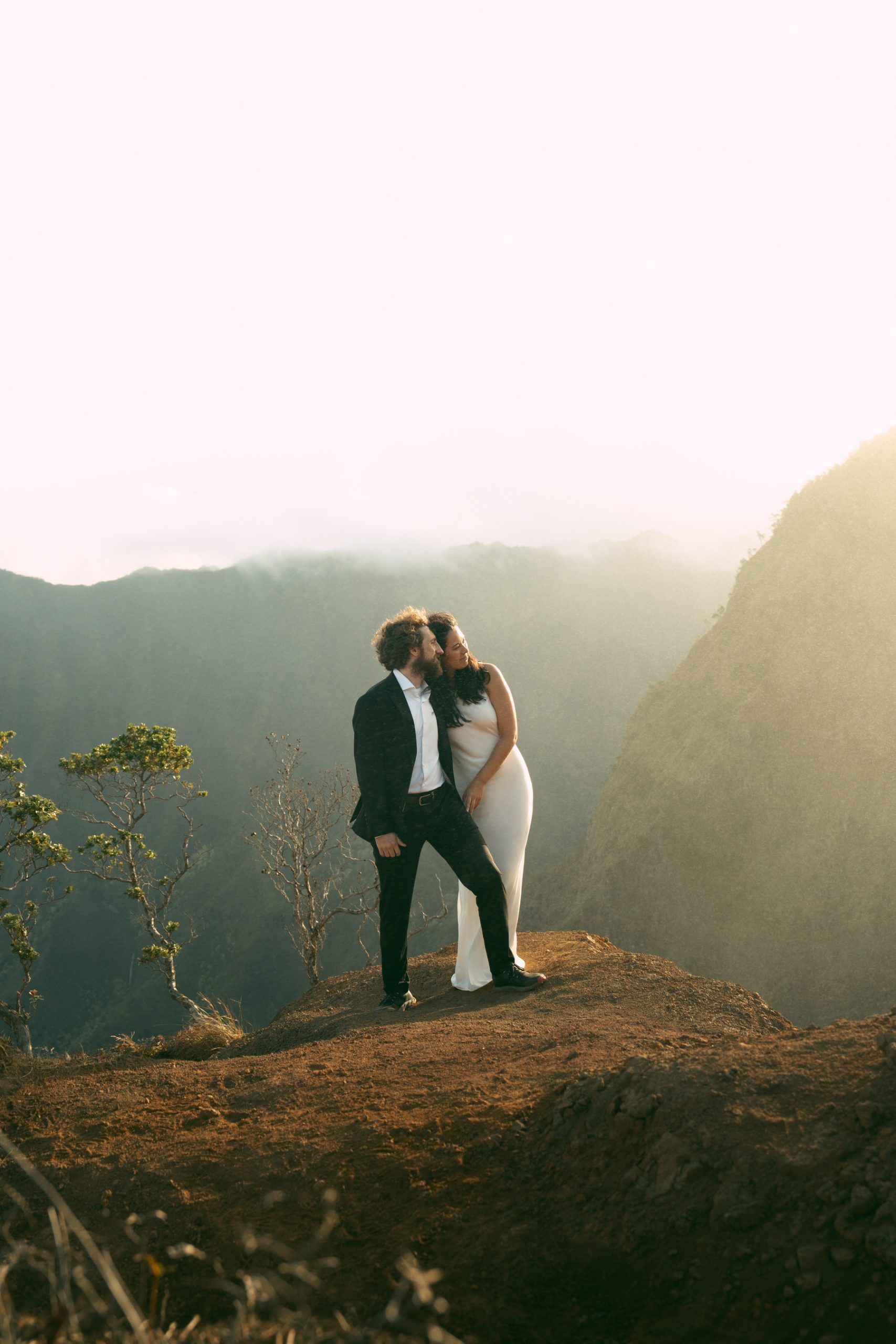 Bride and groom enjoy sunrise in the Waimea Canyon in Hawaii.