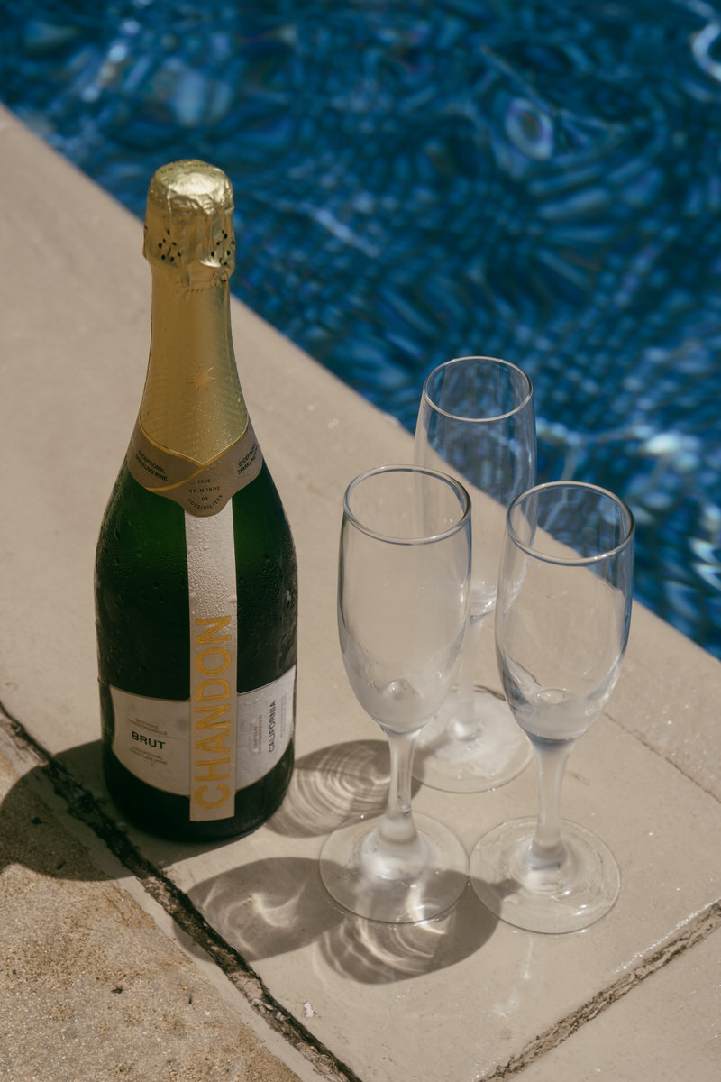 Champagne and flutes arranged by the pool.