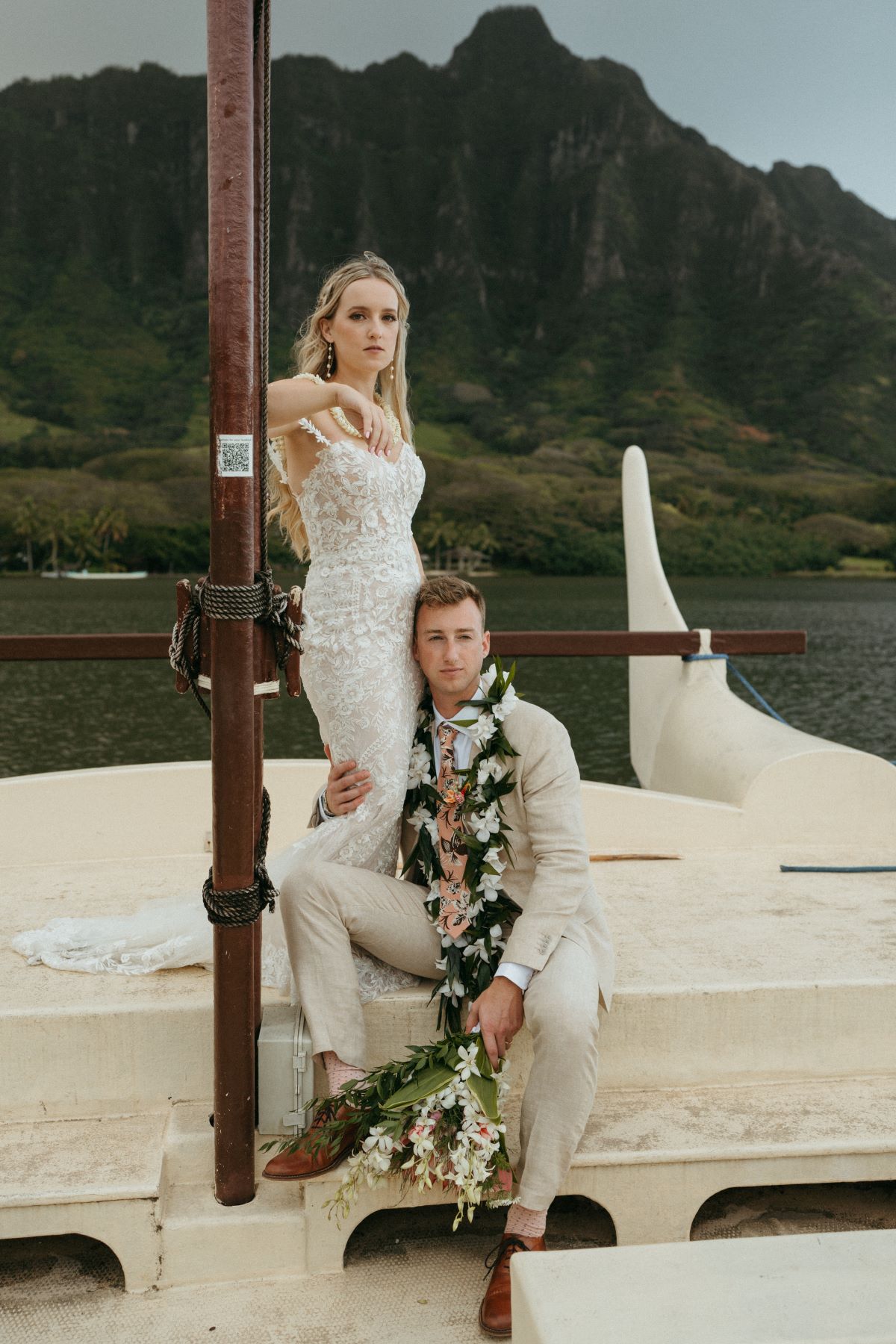 Bride and groom posing on boat shuttle heading to Secret Island on Oahu.