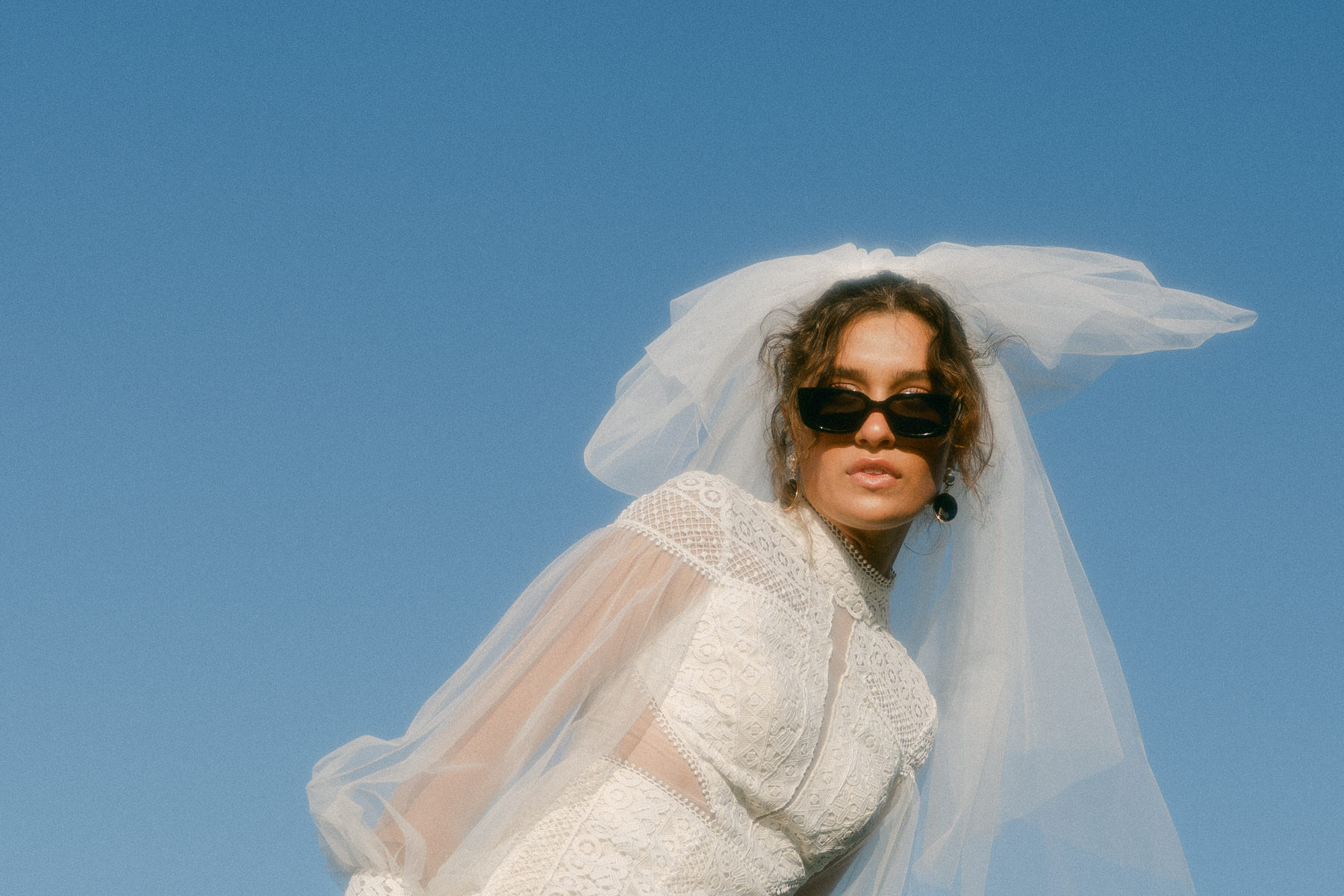 Bride is adorned in designer sunglasses and a couture and vintage veil.
