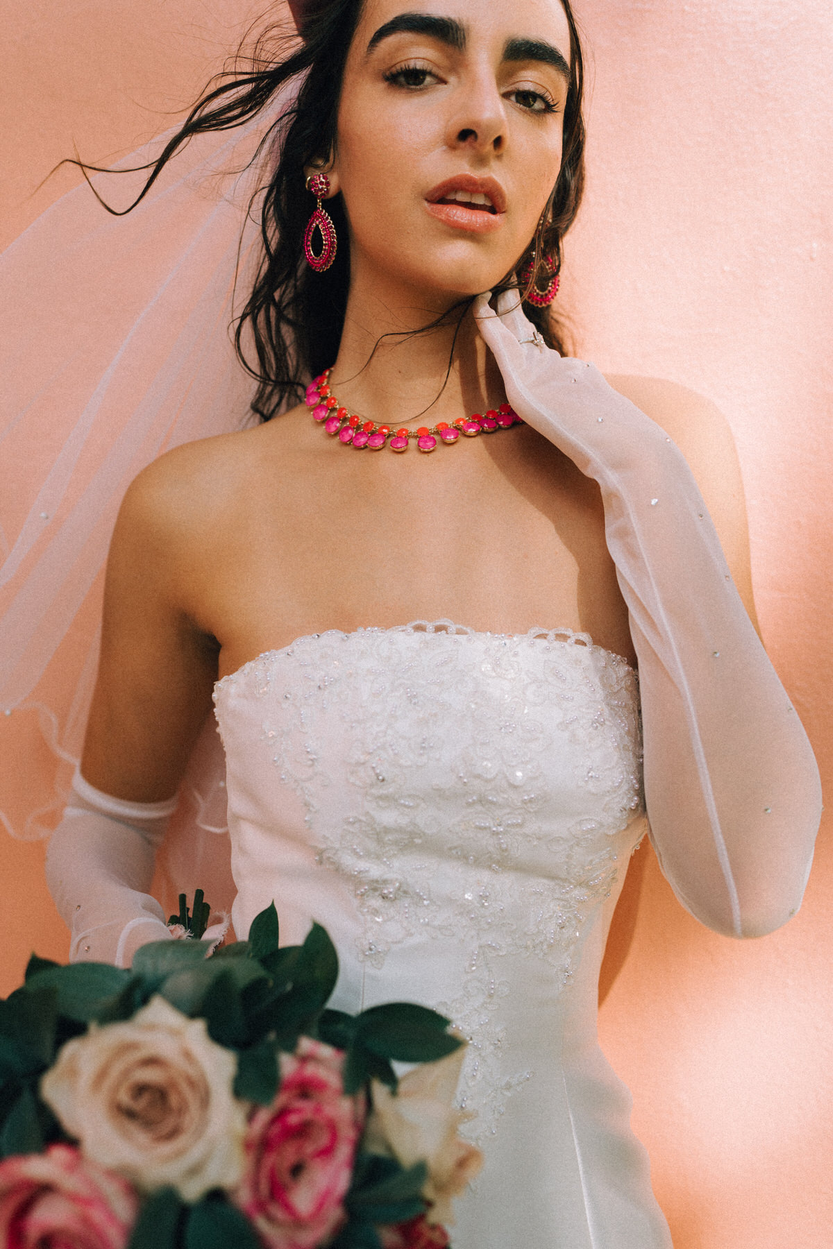 Pink bridal details including necklace, earrings, and flowers.