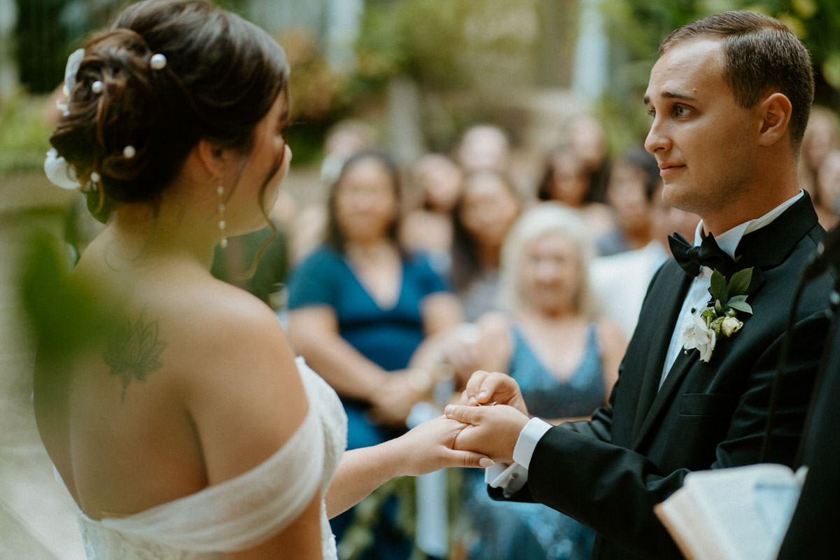 Documentary wedding photographer captures ring exchange during ceremony.