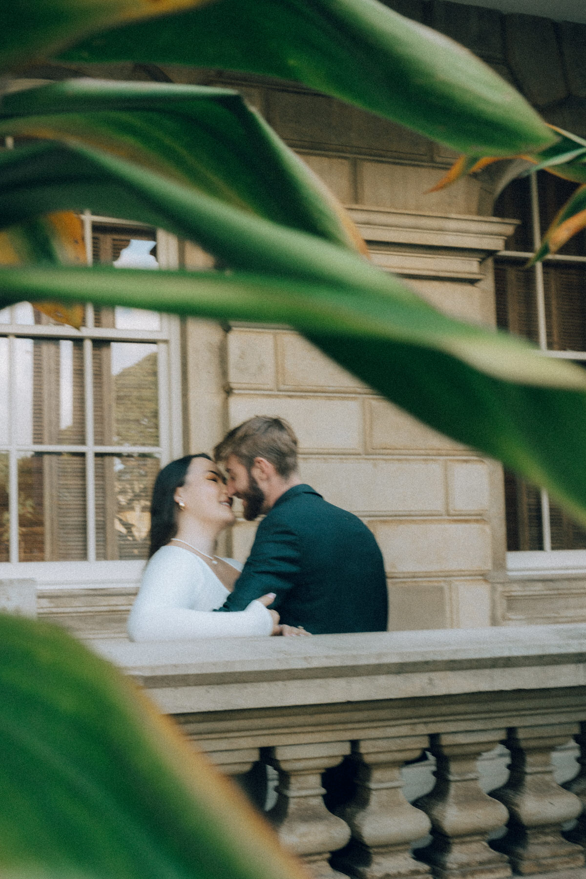 A young couple shares a private kiss during their engagement session.