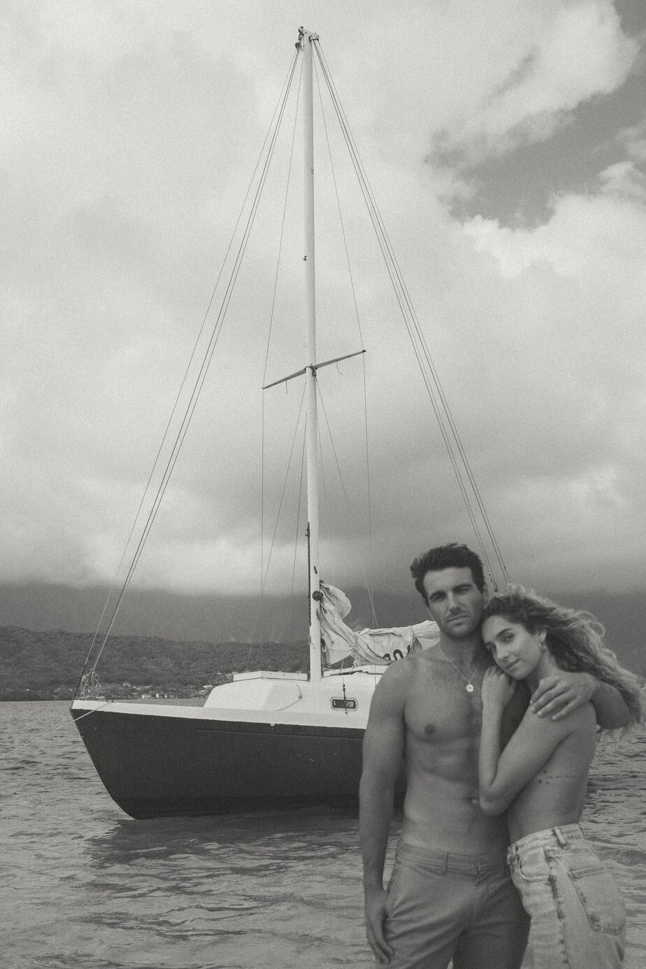 Couple poses in front of boat.