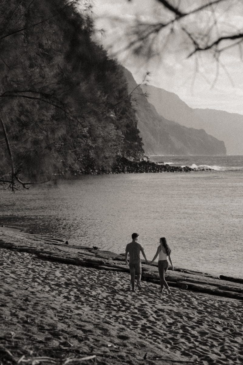 Black and white photo of bride and groom on beach during Oahu couples photo session.