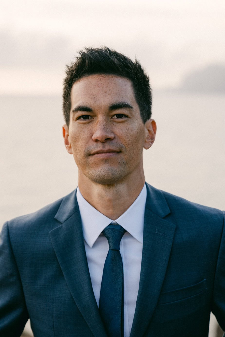 A man has stoic smile during Oahu couples photo session.