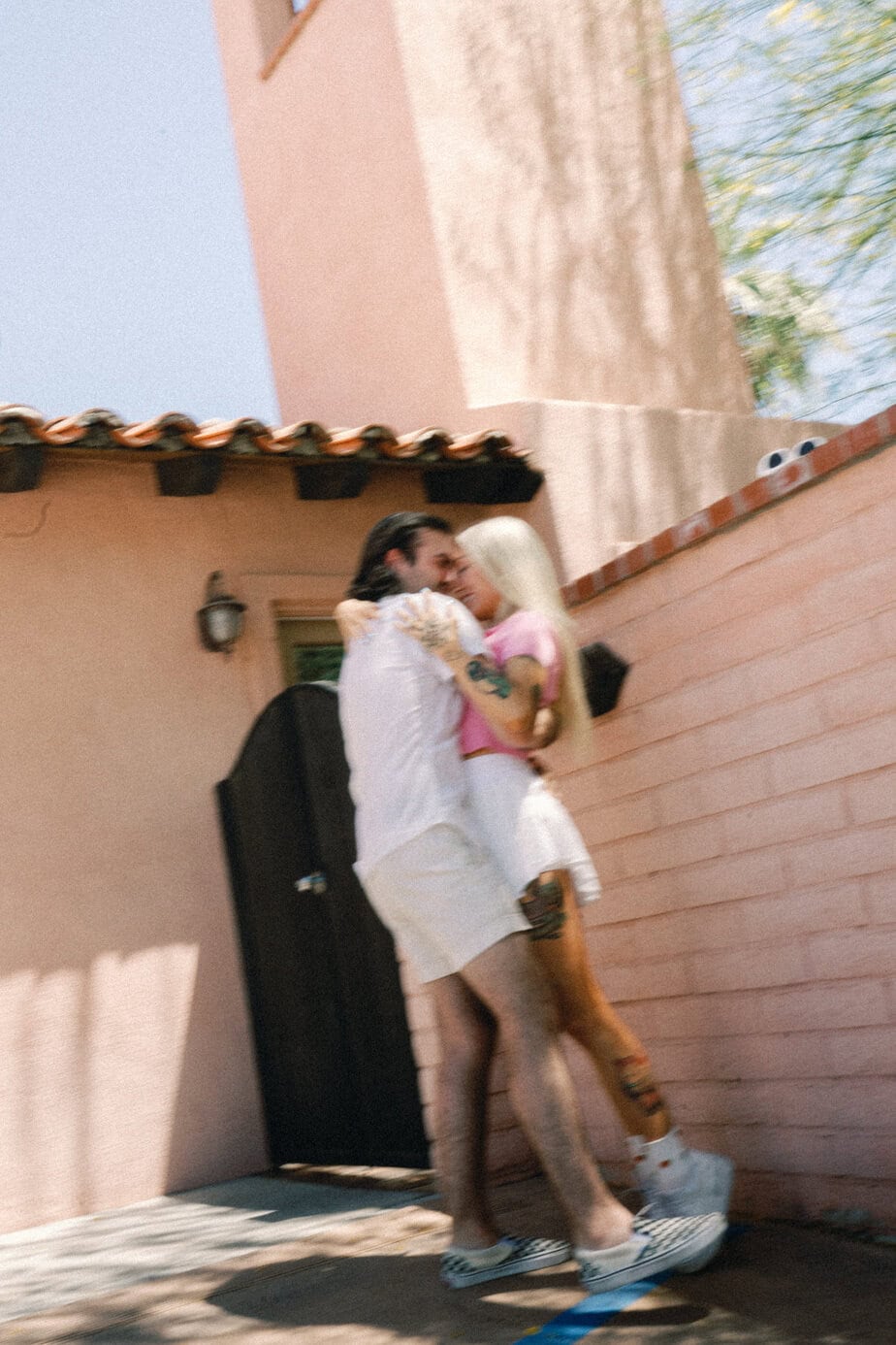 Couple next to pink hotel in Palm Springs.