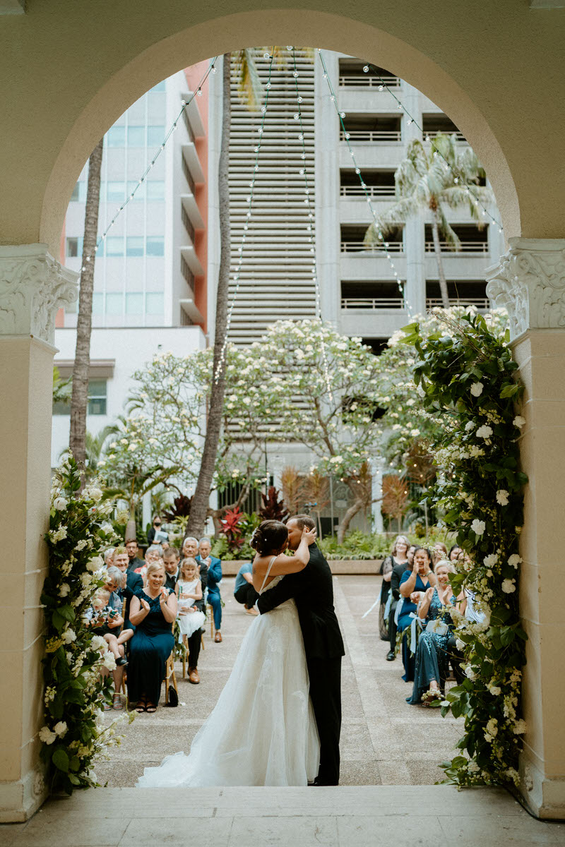 Couple shares kiss after ceremony at Cafe Julia Oahu. Best Oahu Wedding Venues