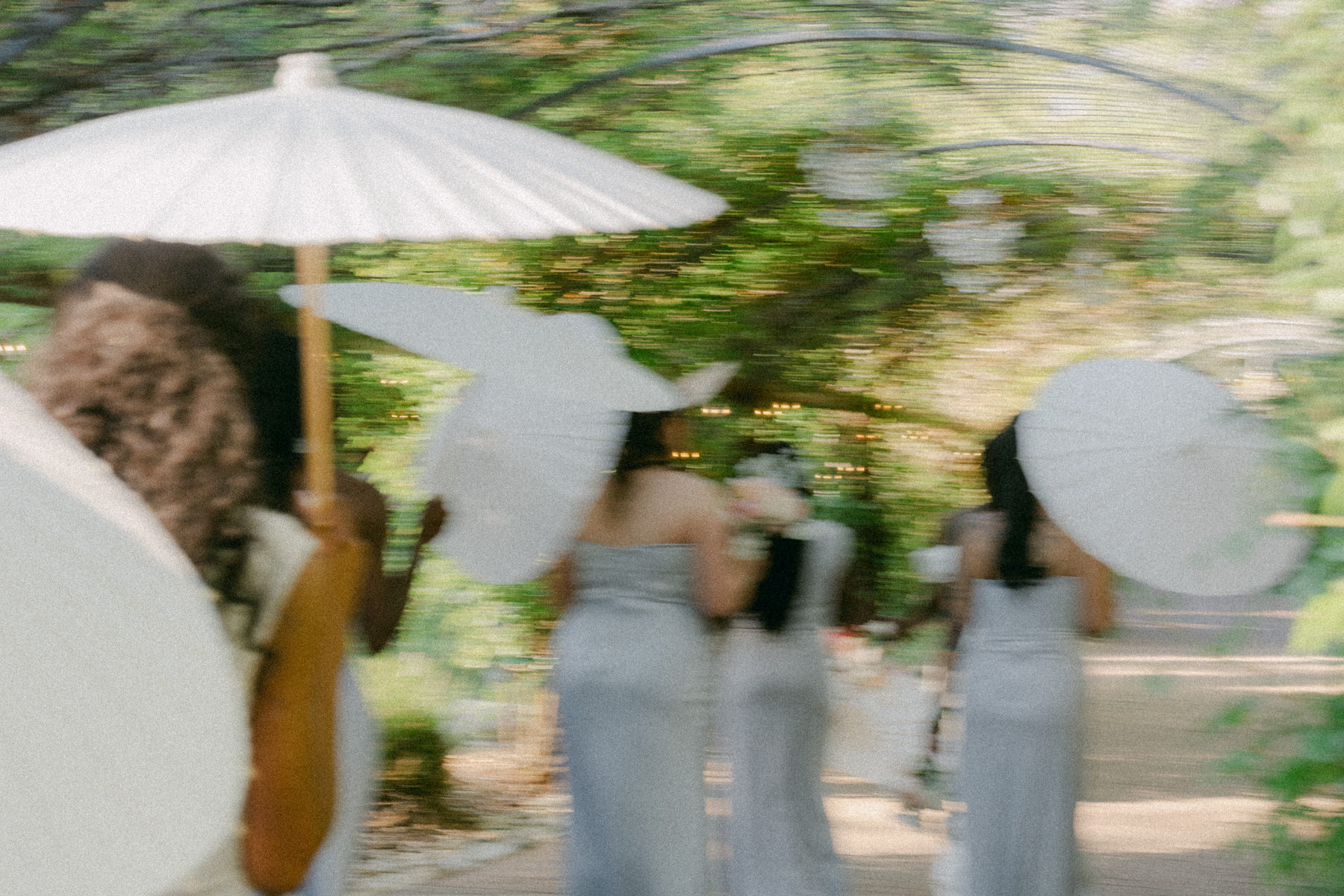 Bridesmaids with parasols at Serendipity Gardens wedding.