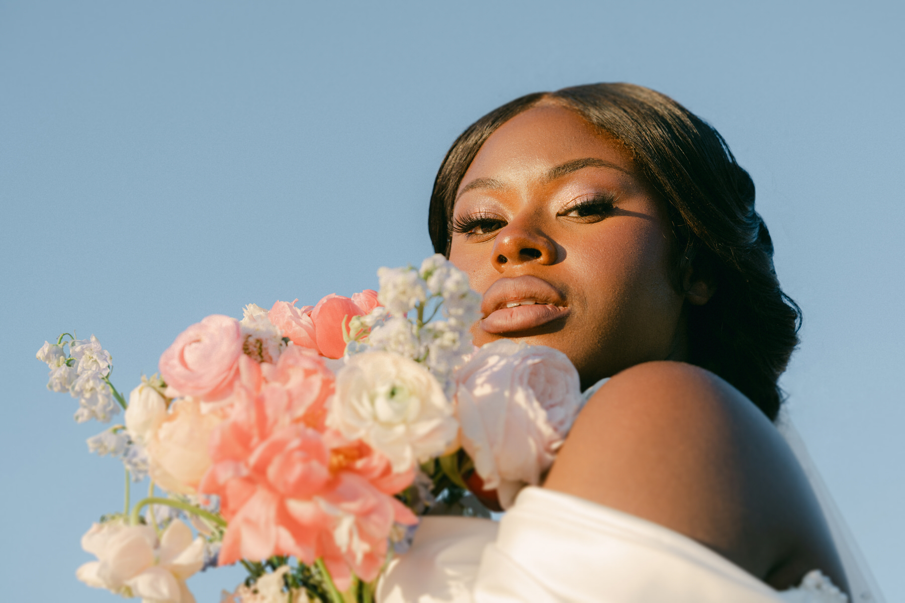 A bride poses with flowers during her Serendipity Gardens wedding.