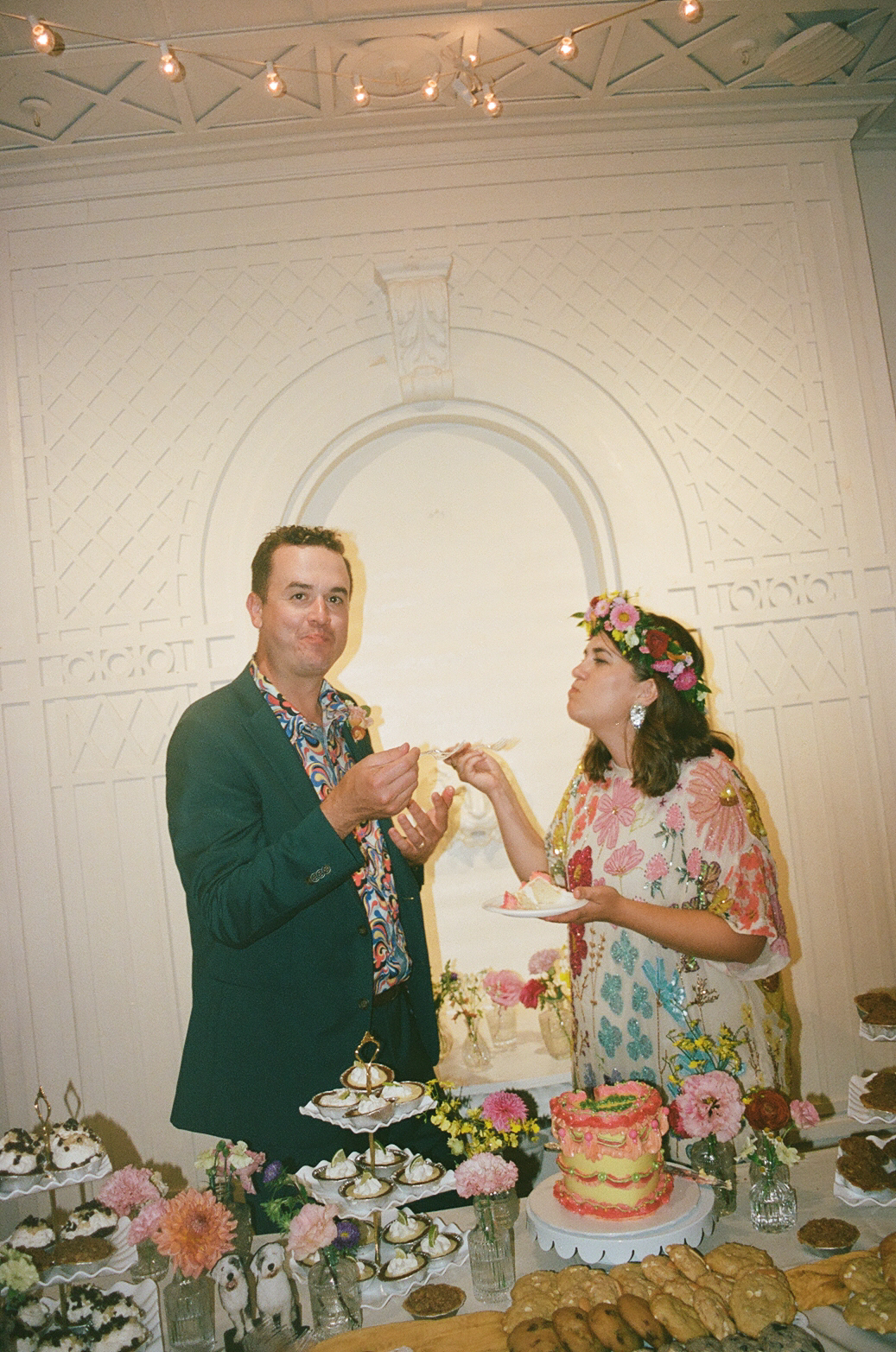 Film photo of a couple enjoying their wedding cake.