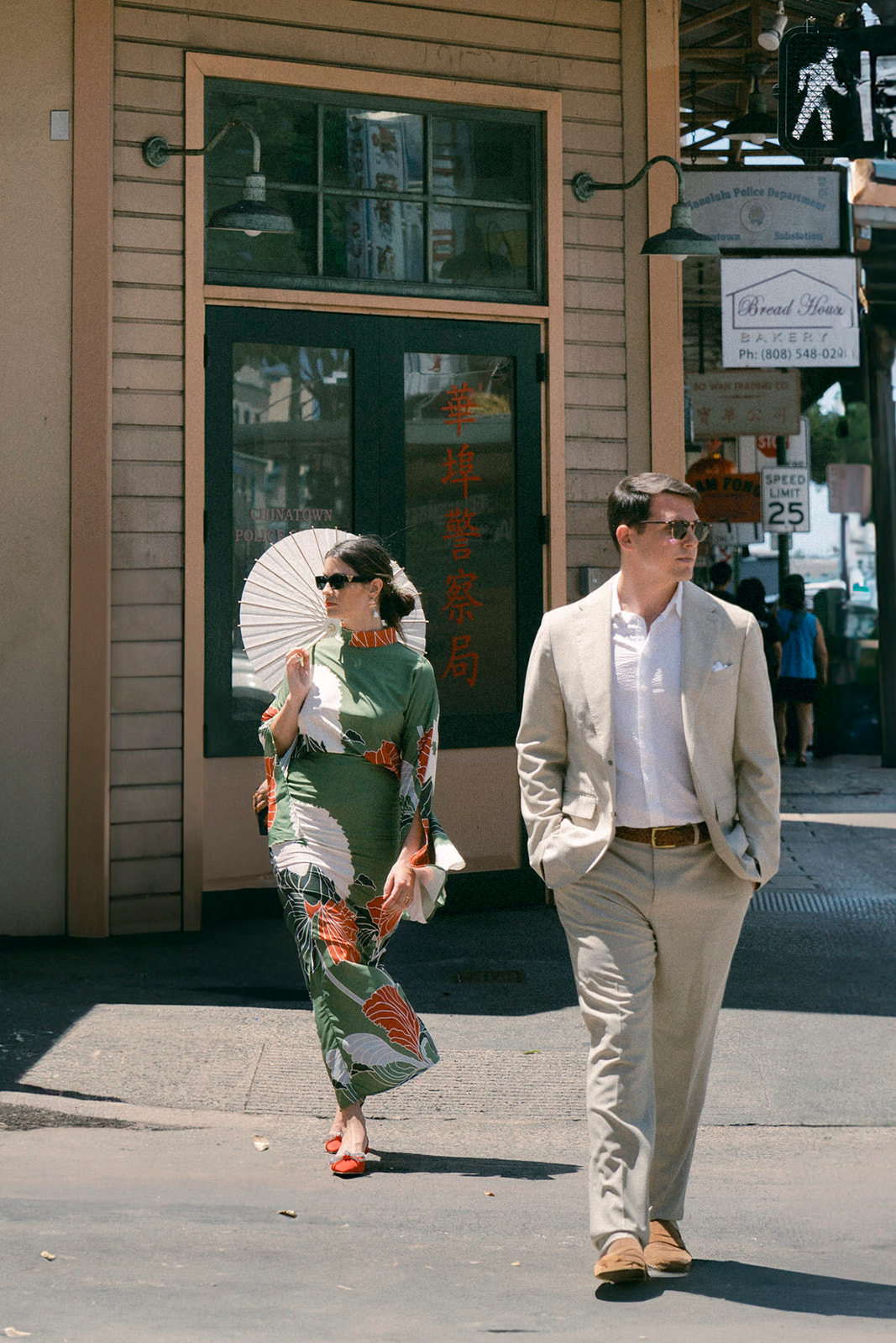 A stylish couple walks the streets of downtown Honolulu during their Oahu couples photo session.