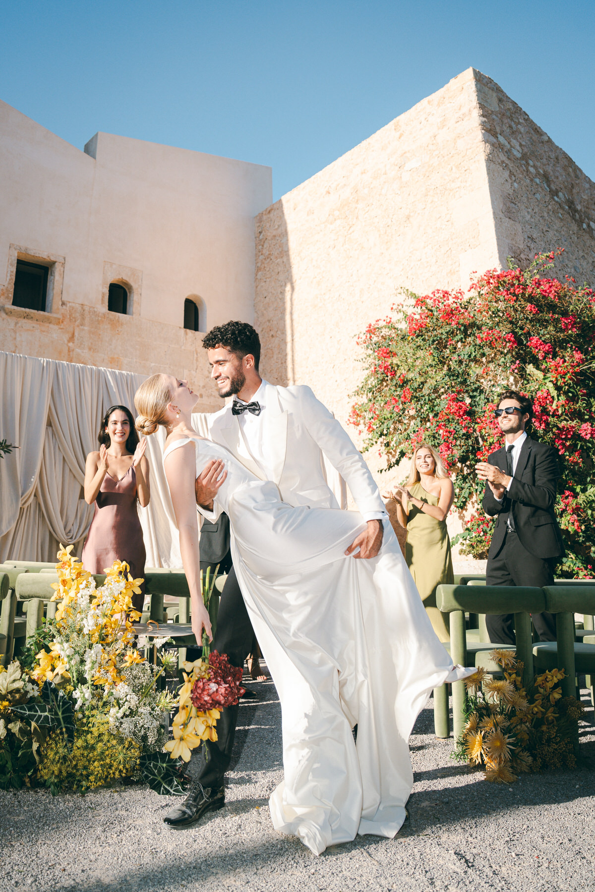 A couple shares kiss and dip after wedding ceremony in Mallorca.