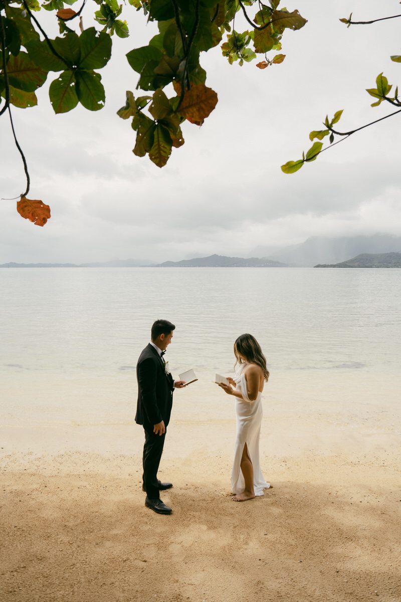 Bride and groom walking along Oahu’s shoreline