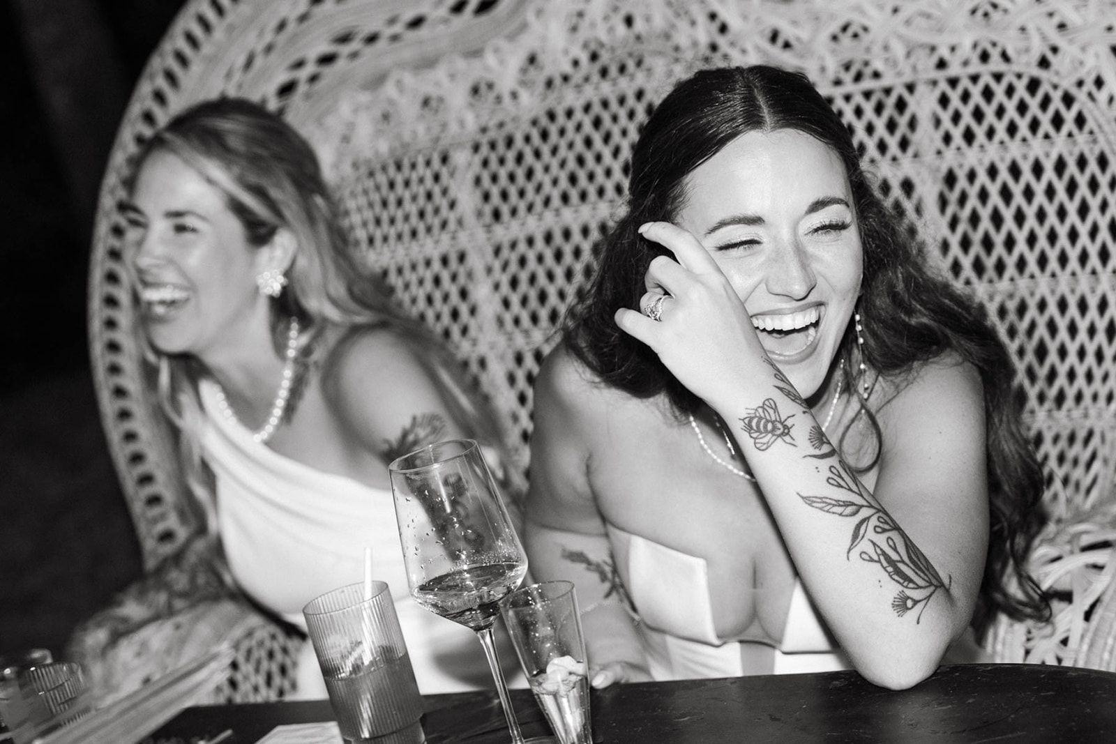Bride and guest sharing a joyful laugh at their wedding reception in Oahu, captured in Wedding Photography on Oahu.