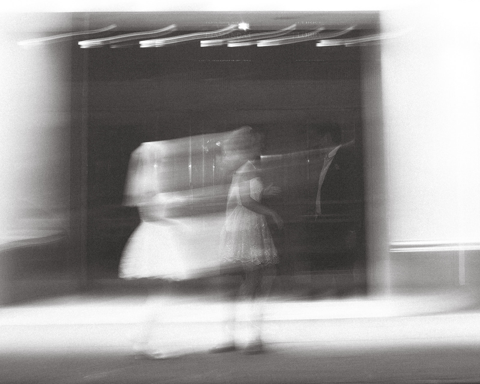 A blurred, motion shot of a couple, capturing a sense of movement and intimacy during the evening.