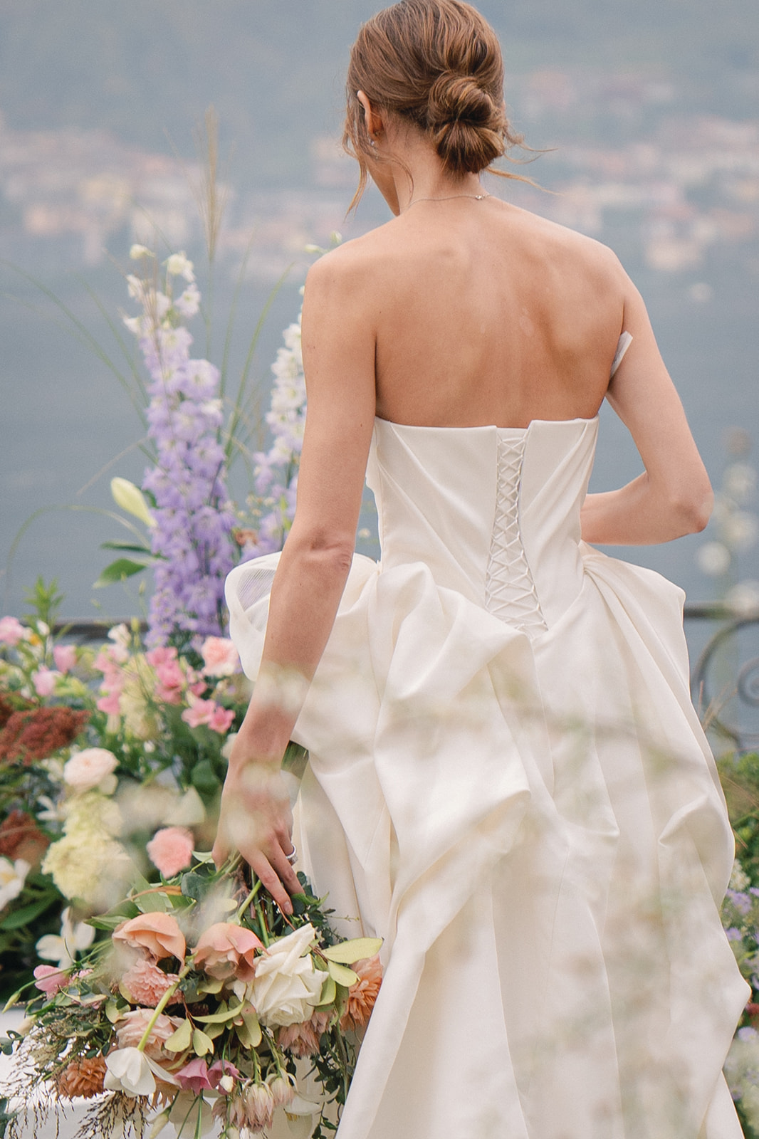 A candid shot of the bride walking with her bouquet in hand, surrounded by lush greenery and flowers.