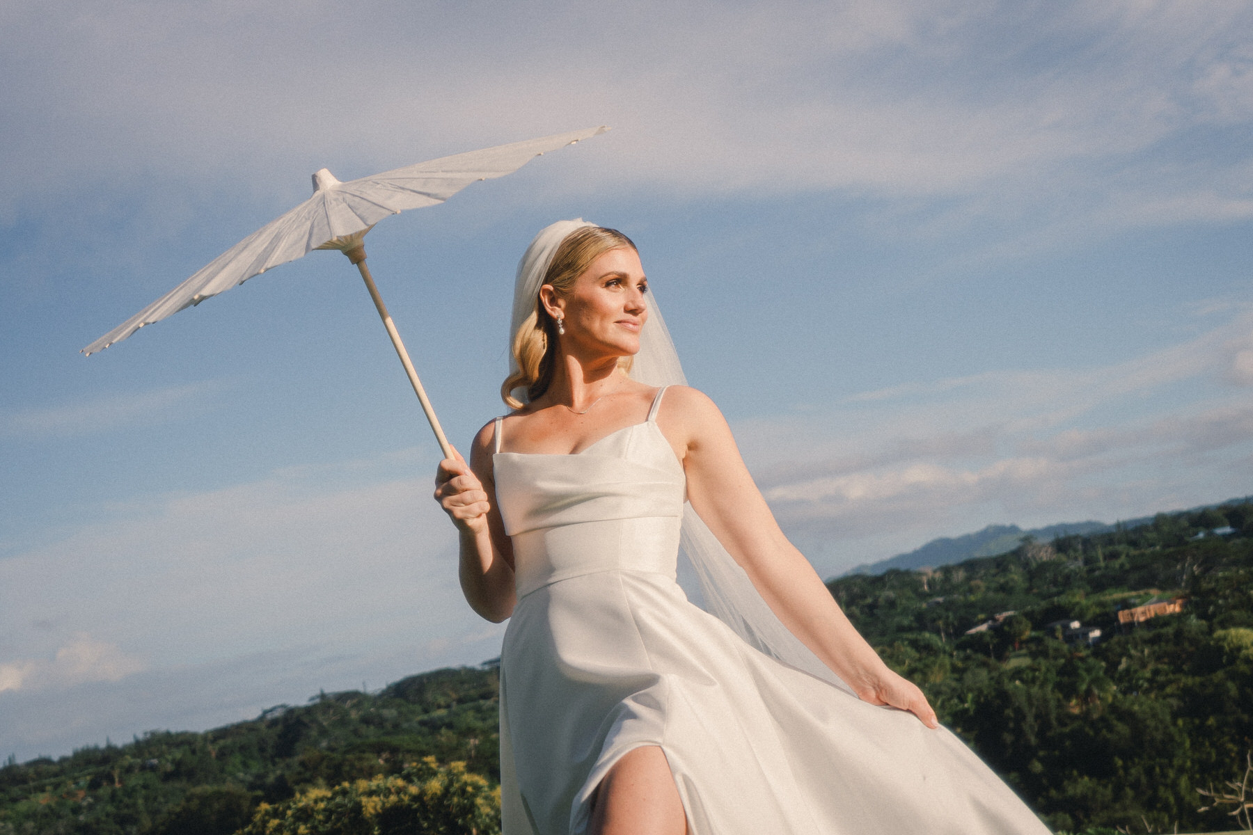 Wedding reception tent decorated with hanging lanterns and lush tropical greenery, creating a beautiful ambiance in Wedding Photography on Oahu.