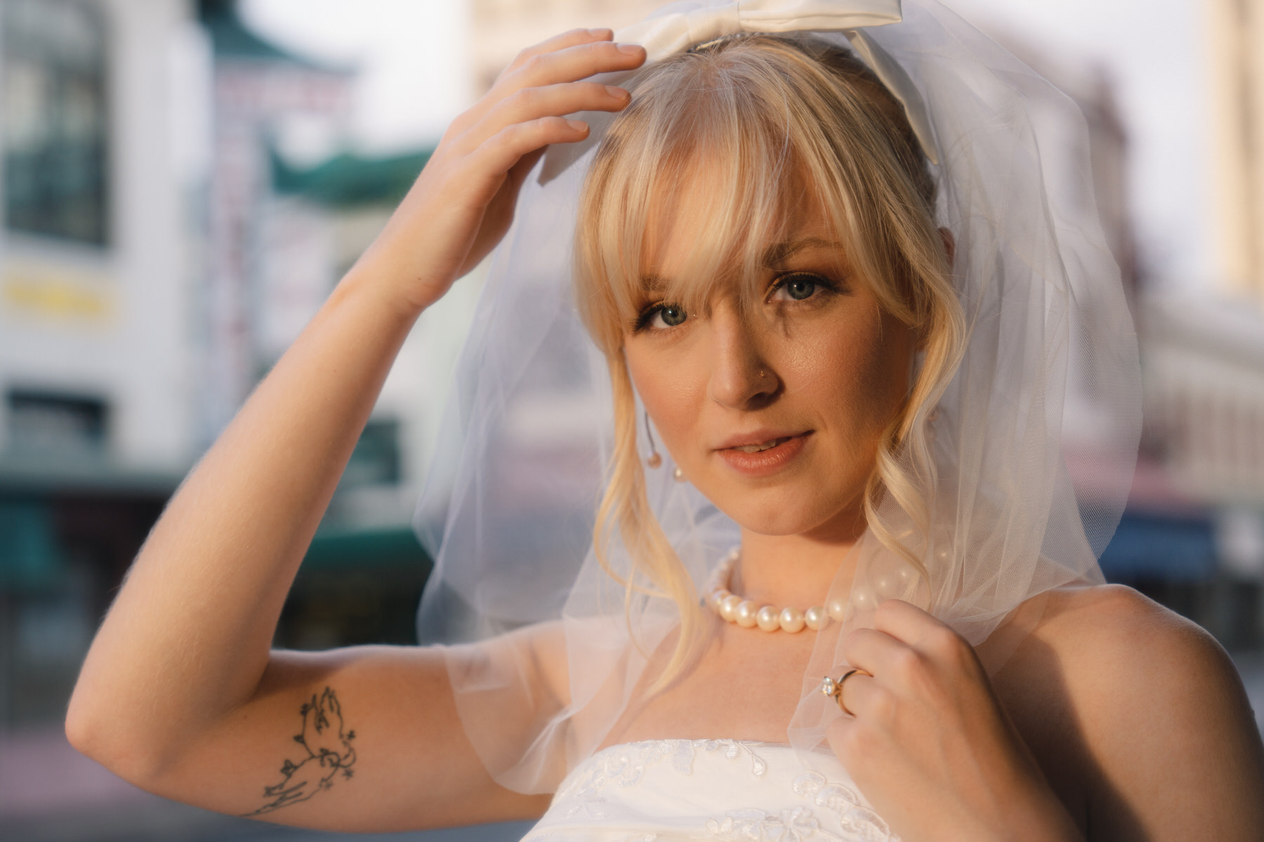 Bride holding her veil as she gazes softly at the camera, showcasing her bridal elegance in Bridal Photography in Hawaii