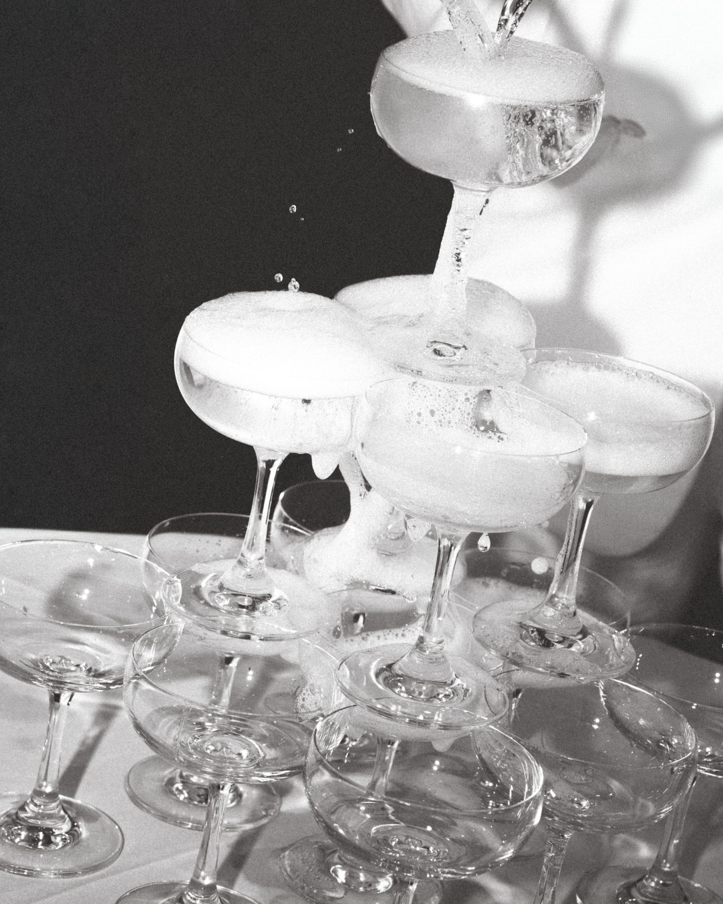 Champagne glasses cascading in a pyramid shape with bubbly champagne pouring over, captured in Wedding Photography on Oahu.