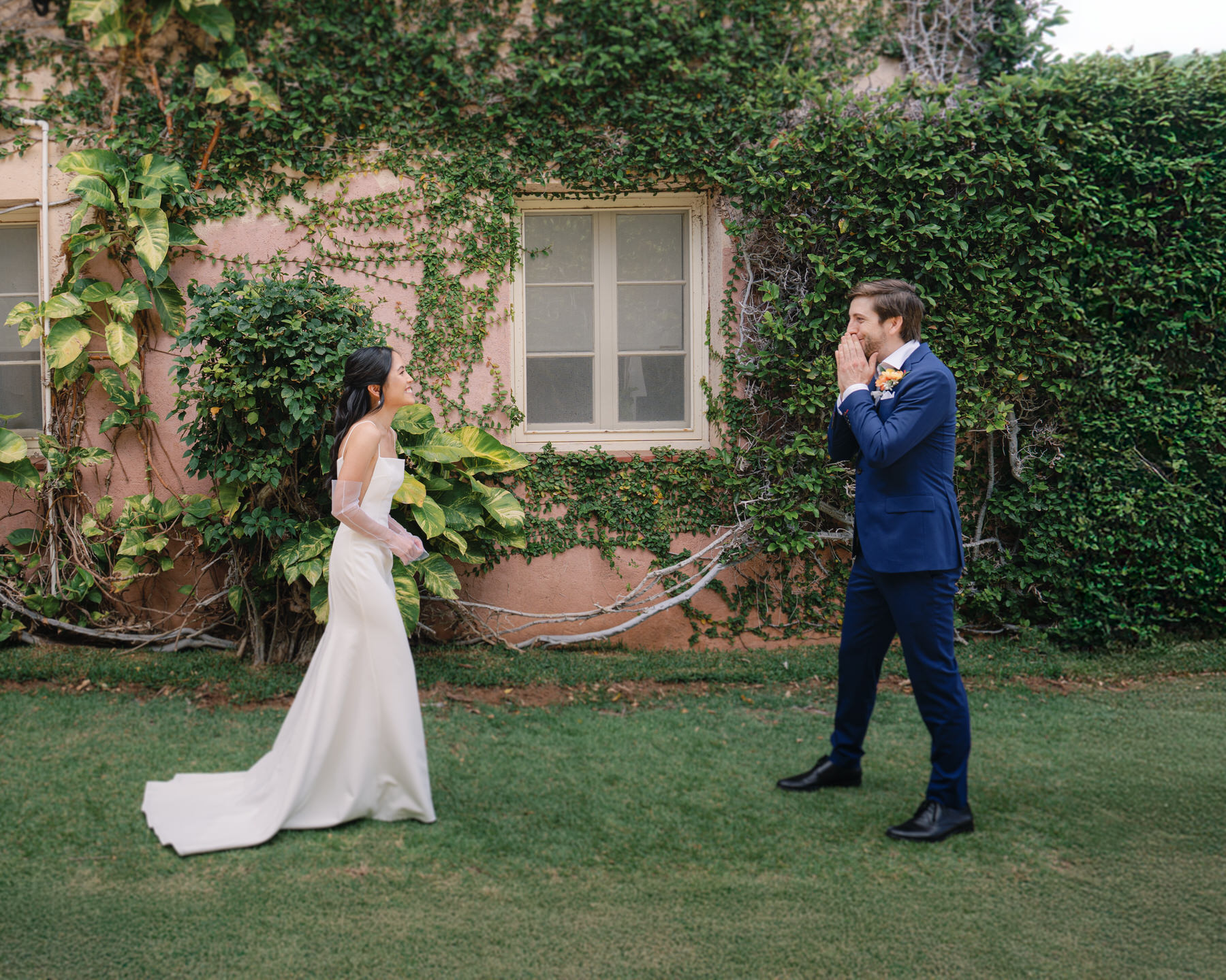 The groom gets emotional as the bride approaches during their first look, standing in front of La Pietra’s ivy-covered pink villa—tender moments captured in La Pietra Wedding: A Guide for Modern Couples.