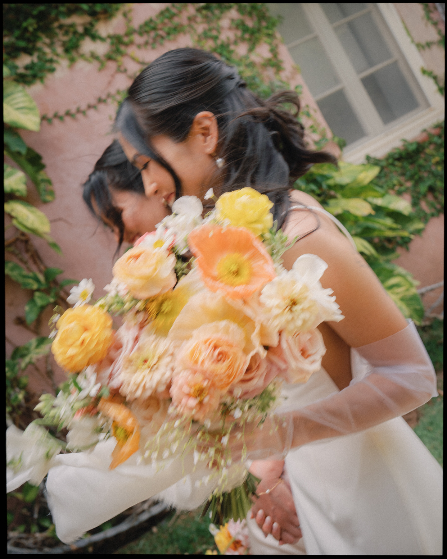 A soft-focus shot of the bride holding a vibrant bouquet of poppies, roses, and ranunculus—capturing the floral moodboard in La Pietra Wedding: A Guide for Modern Couples.