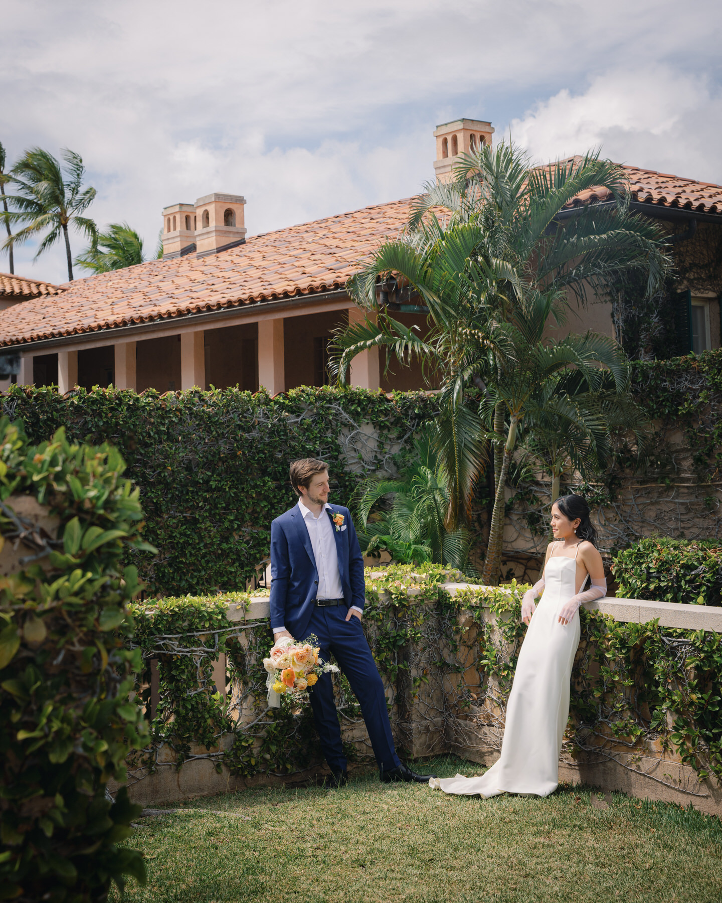 The bride and groom share a quiet moment in a sun-drenched garden at La Pietra, surrounded by tropical greenery and classic architecture—intimate romance in La Pietra Wedding: A Guide for Modern Couples.