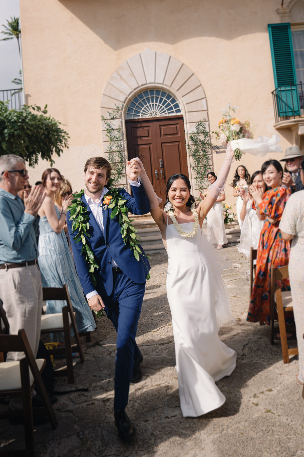 A joyful couple walks down the aisle, hand-in-hand, just married and surrounded by cheers, embodying modern love at La Pietra Wedding: A Guide for Modern Couples.
