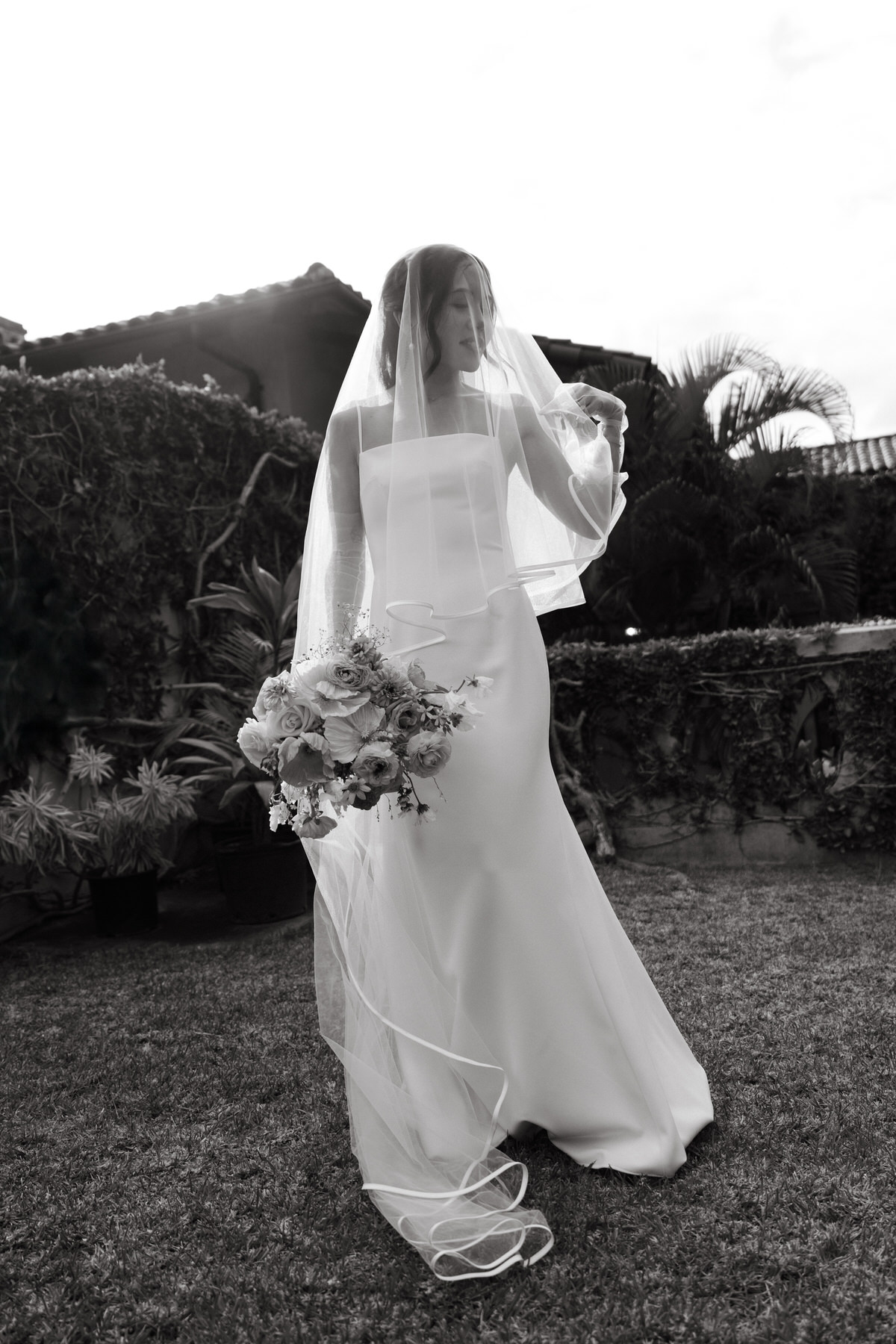 A timeless black-and-white portrait of a bride in a sleek gown and veil, holding a delicate bouquet at La Pietra—pure elegance in La Pietra Wedding: A Guide for Modern Couples.