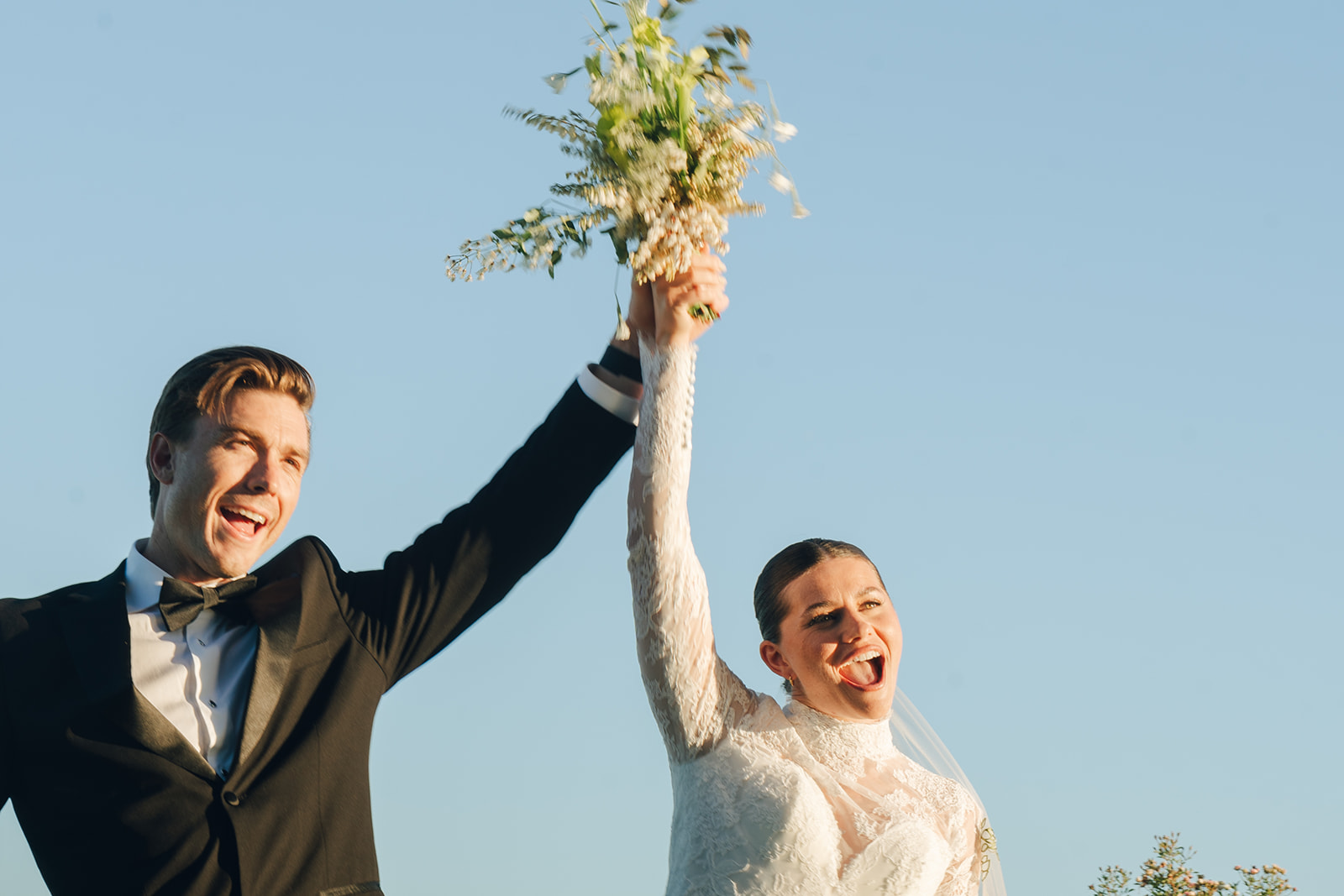 Bride and groom celebrating with raised hands after their elopement ceremony, captured in Elopement Photography in Hawaii.