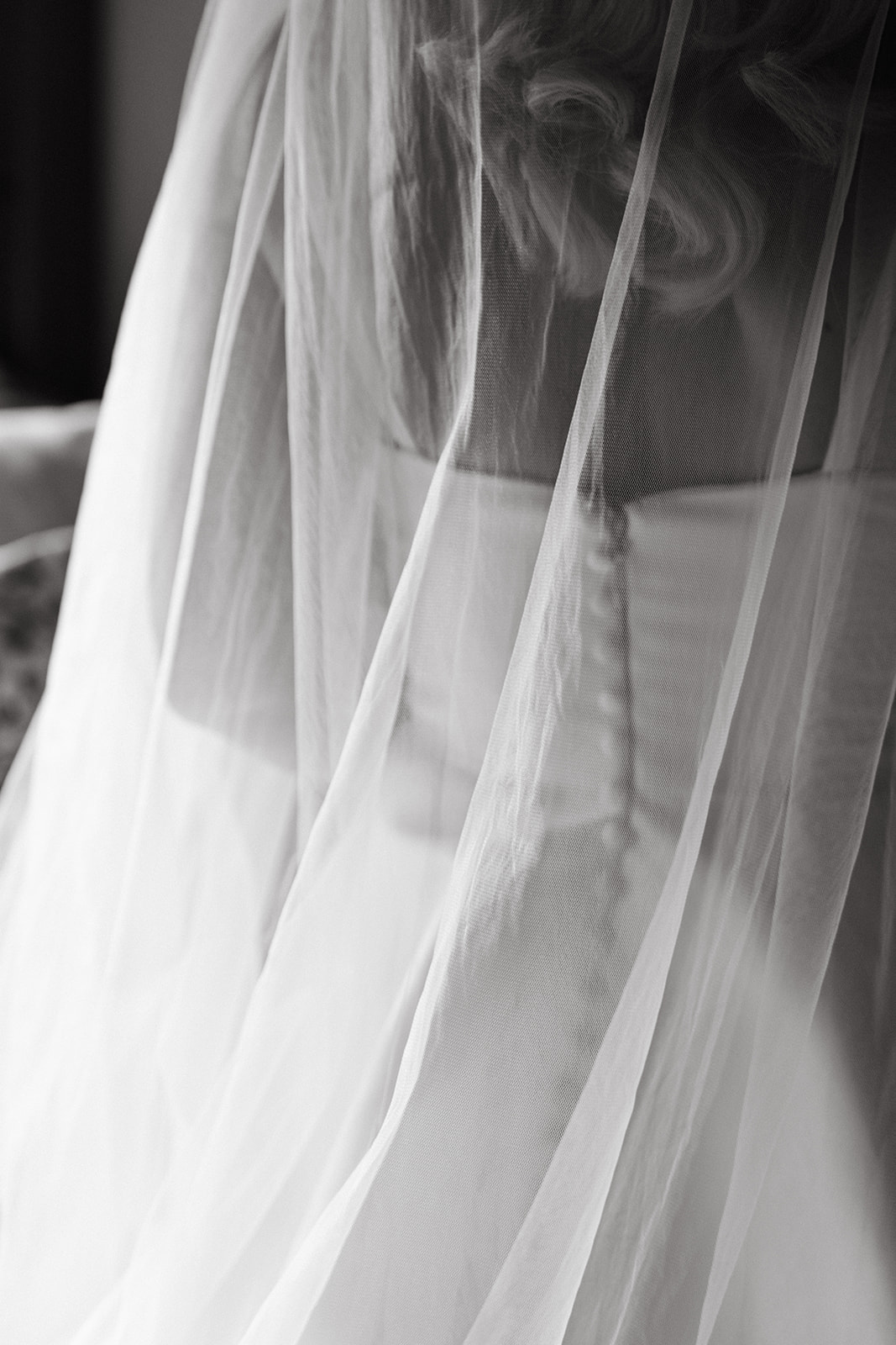 Soft black-and-white close-up of a bridal gown’s button details seen through layers of veil—an elegant texture shot for a Destination Wedding Photography Guide for Couples Planning a Hawaii Wedding.