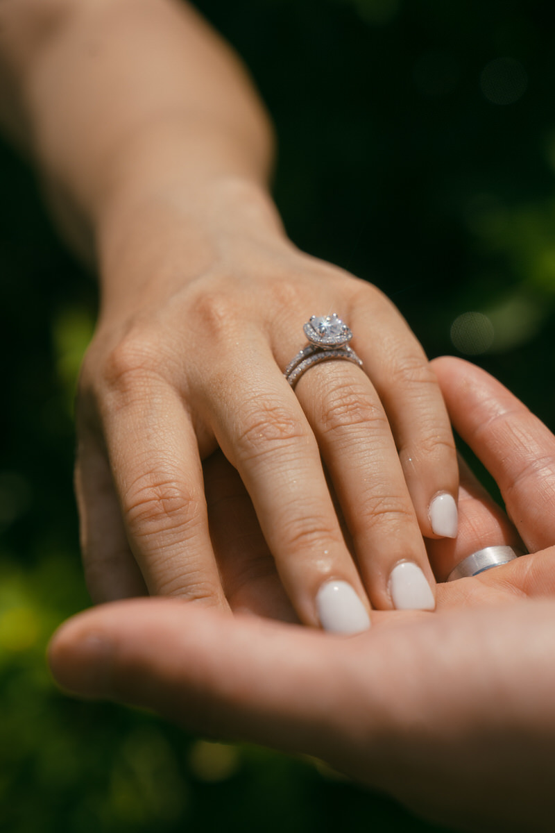 Close-up of a wedding ring being placed on the finger, symbolizing a proposal moment captured in Marriage Proposal Photo Session in Oahu.