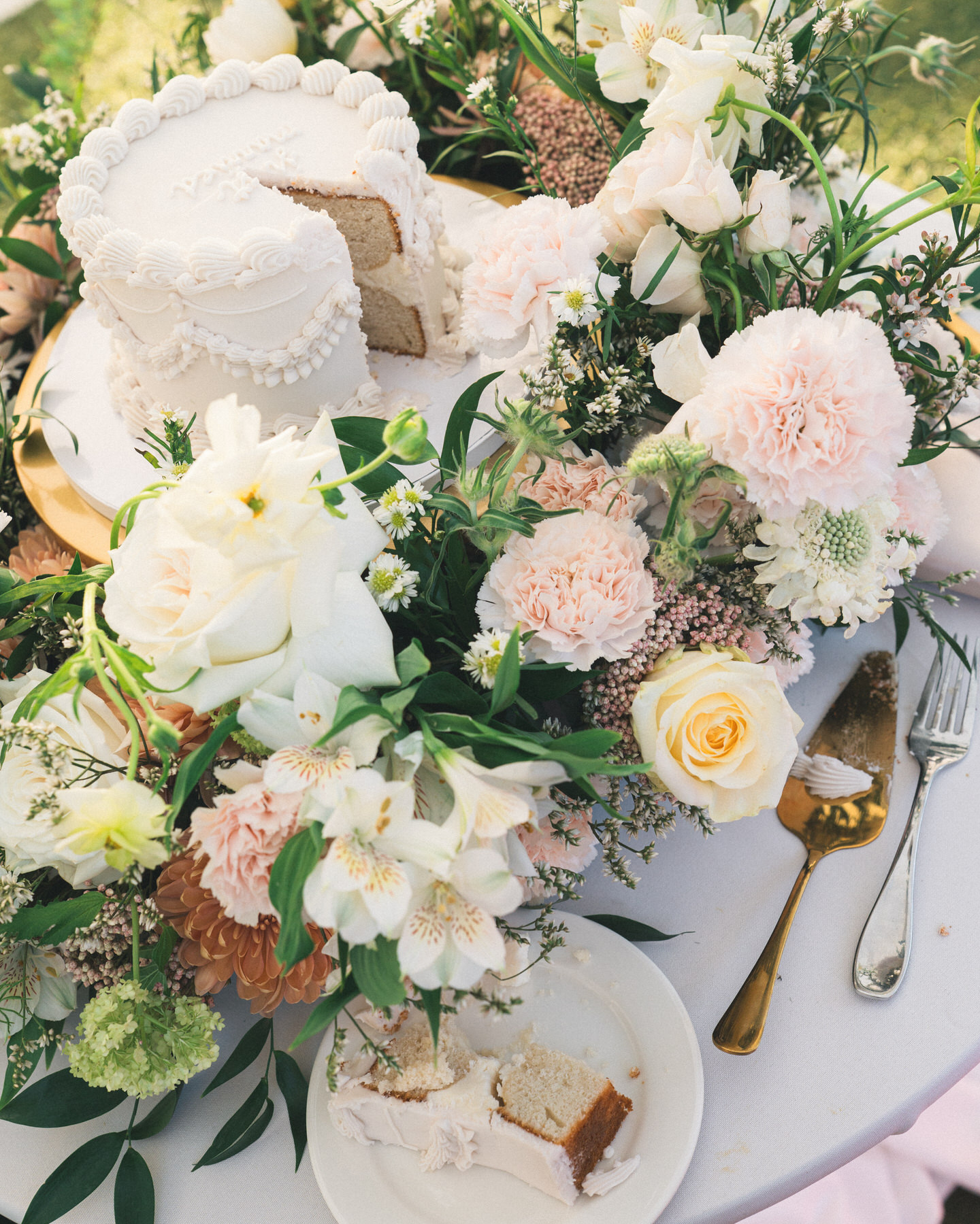 Elegant floral arrangement on the wedding table featuring soft pastels, cake, and fine china, captured in Wedding Photography on Oahu.