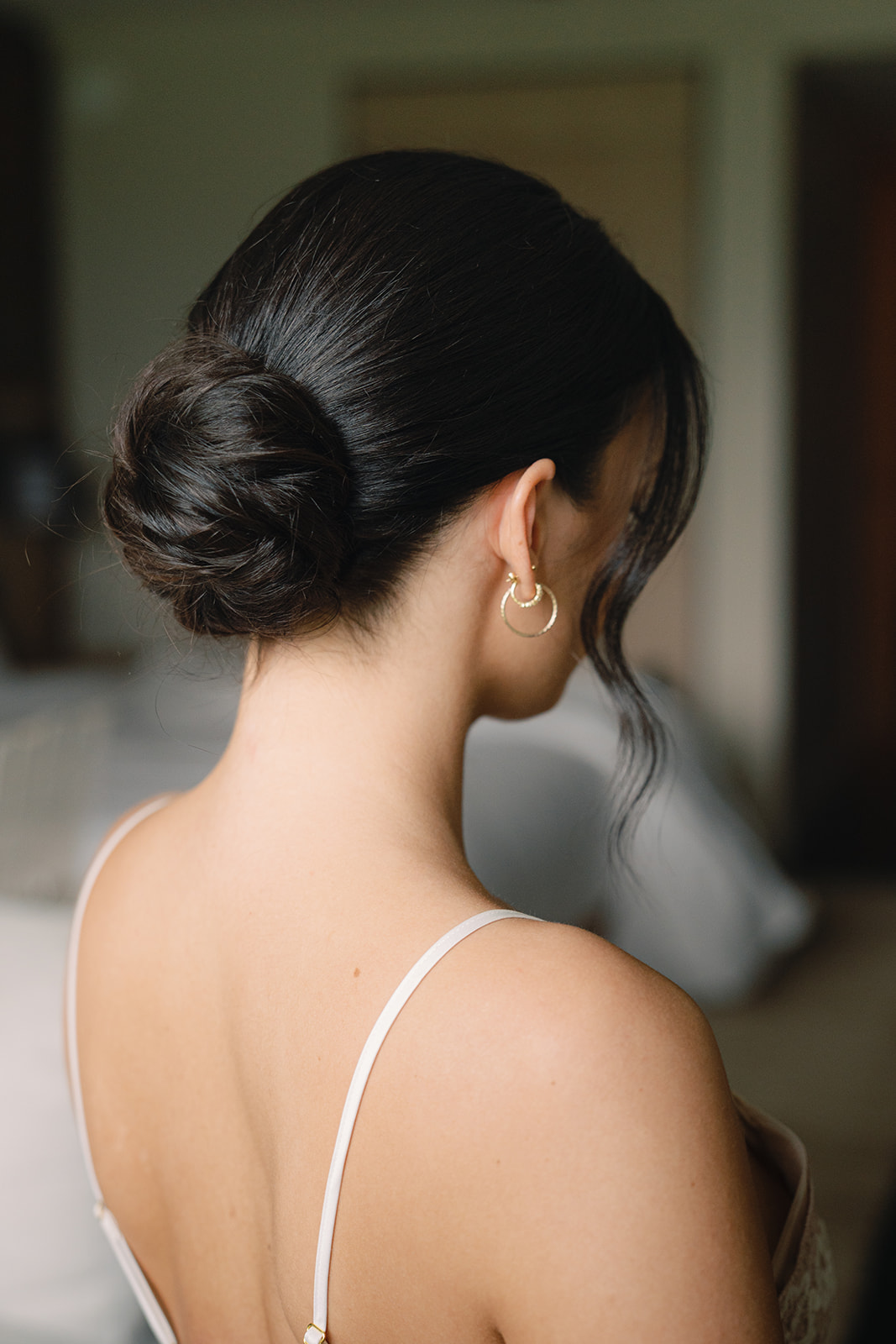 Bride’s low chignon hairstyle with pearl earrings during Sunset Ranch wedding Oahu getting ready session