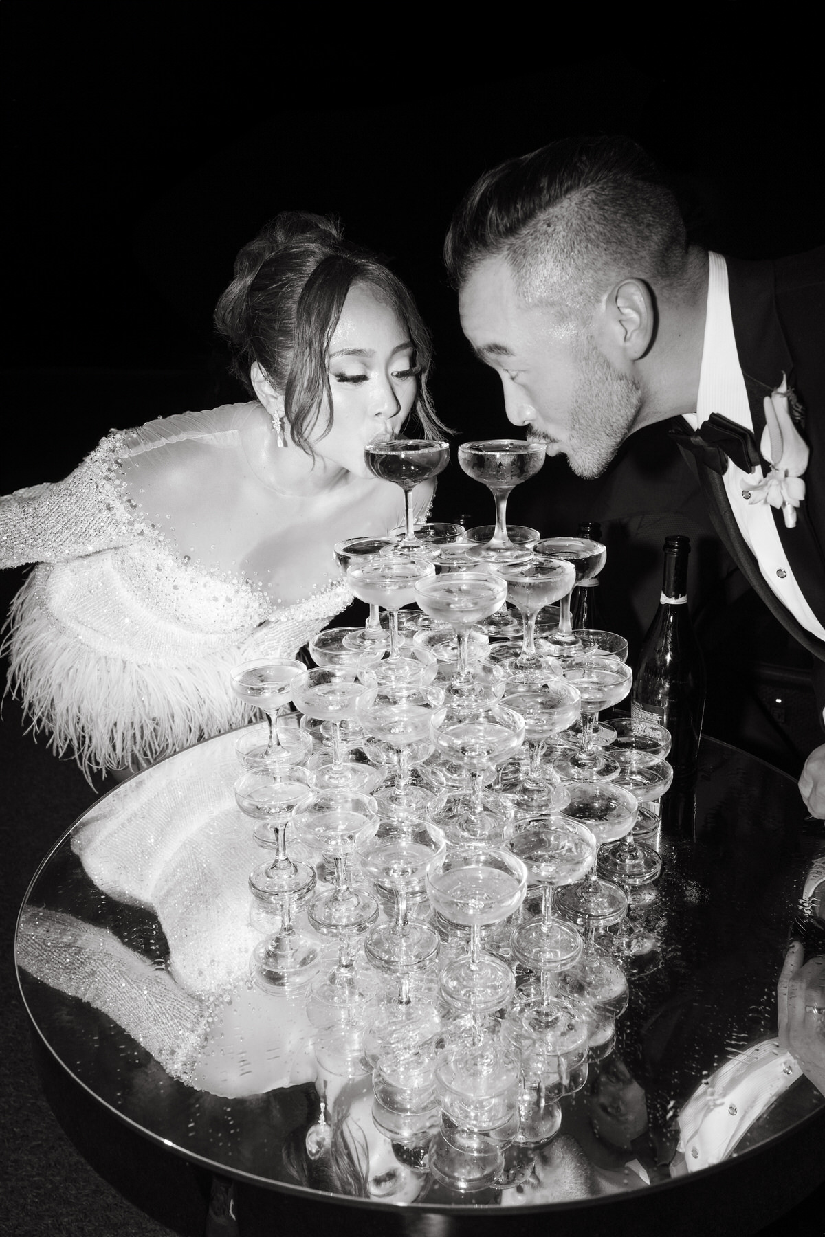 A fun moment at the wedding reception, where the newlyweds toast from a champagne tower. Their elegant attire and the celebratory atmosphere highlight the importance of hiring skilled Oahu wedding vendors to bring such moments to life (and my personal recommendations).