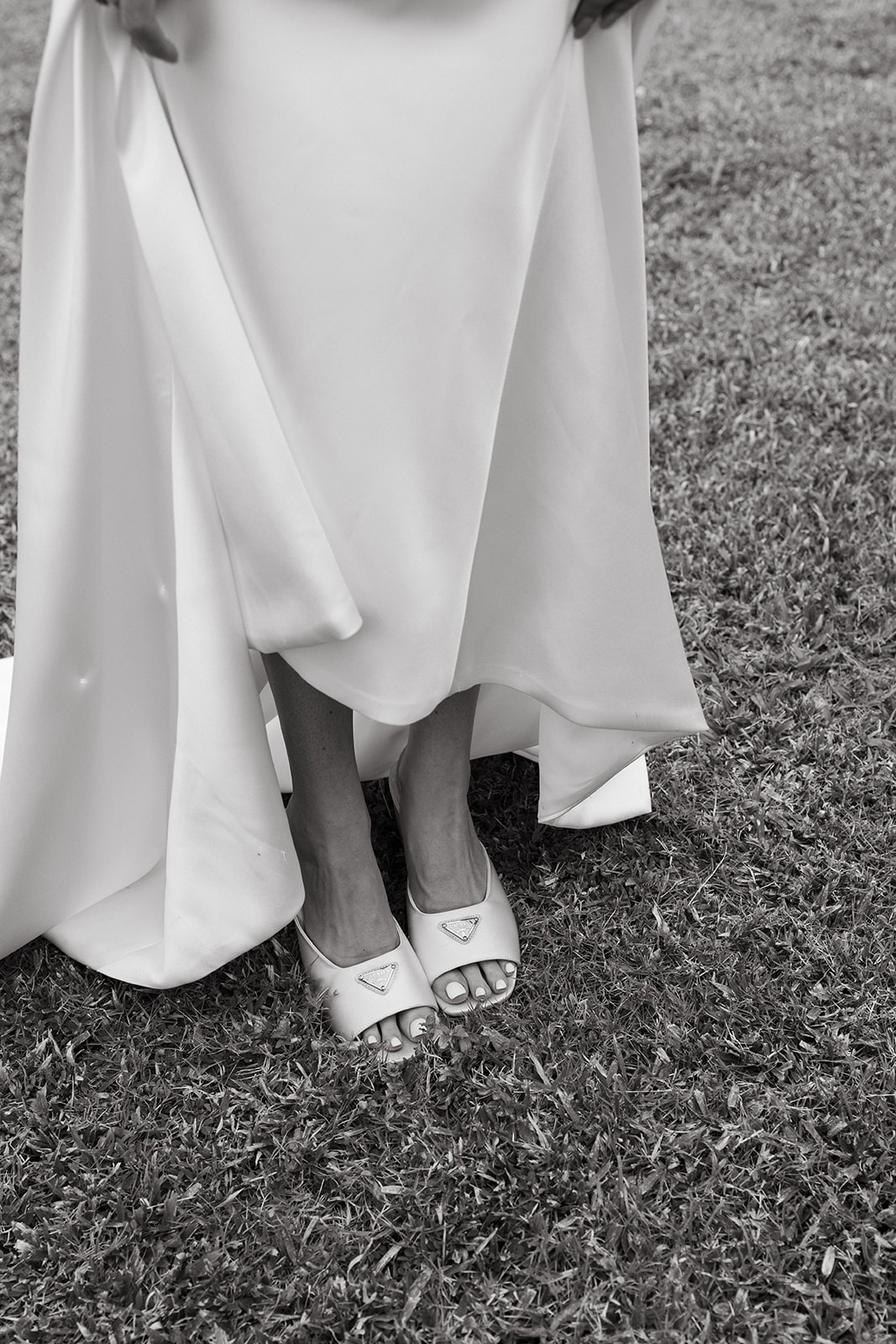 Close-up of the bride’s shoes on the grass at Kualoa Ranch, Paliku Gardens, capturing the elegant details of the wedding day