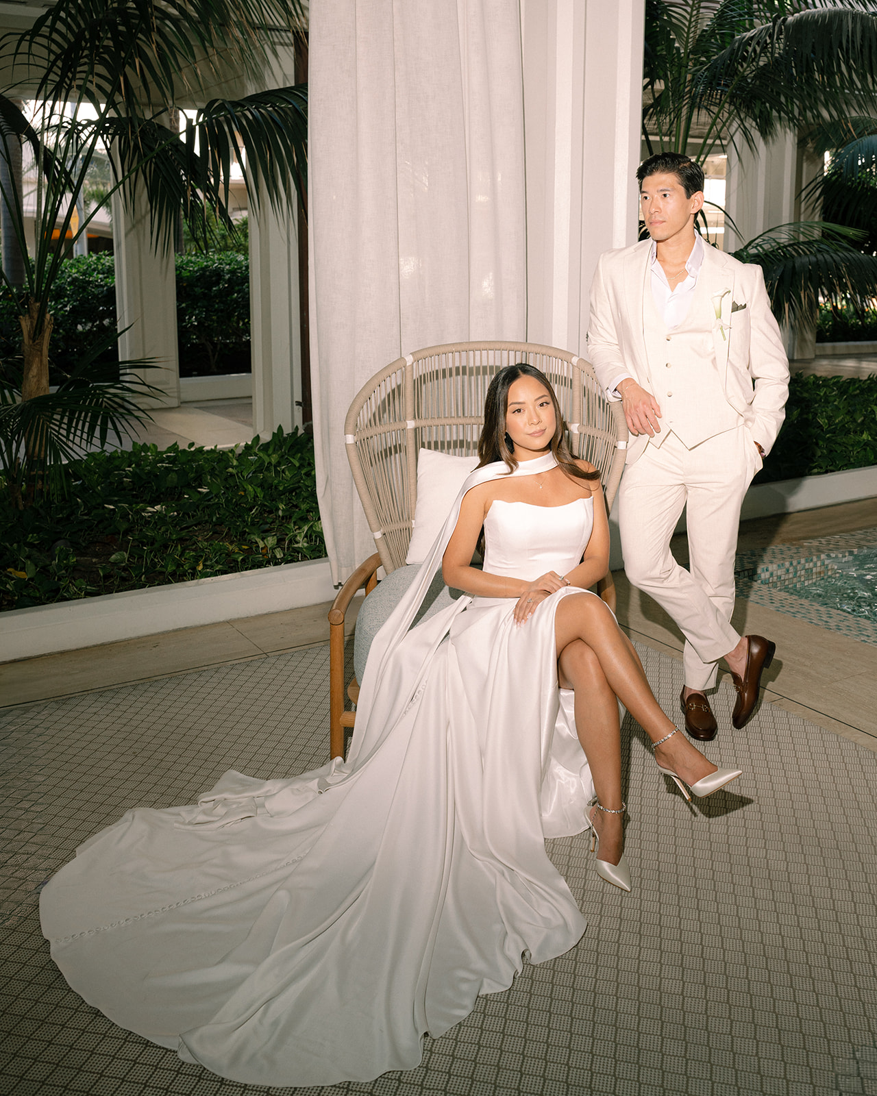 Bride and groom posing elegantly at Halekulani Hotel Waikiki, showcasing timeless style and sophisticated wedding attire in a serene Hawaiian setting.