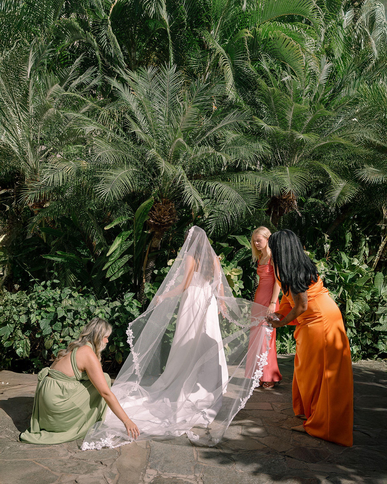 Bride getting ready with bridesmaids before the ceremony at Akala Chapel wedding, surrounded by tropical greenery.