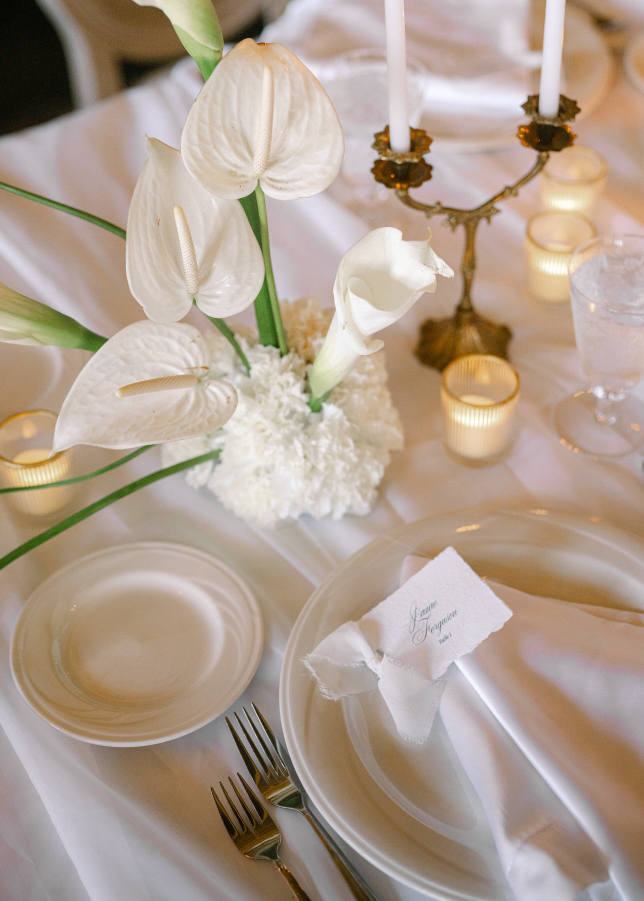 Beautifully set table with white floral arrangements and soft candlelight at the brunch wedding at Ochre Court Newport, showcasing refined details for the reception.