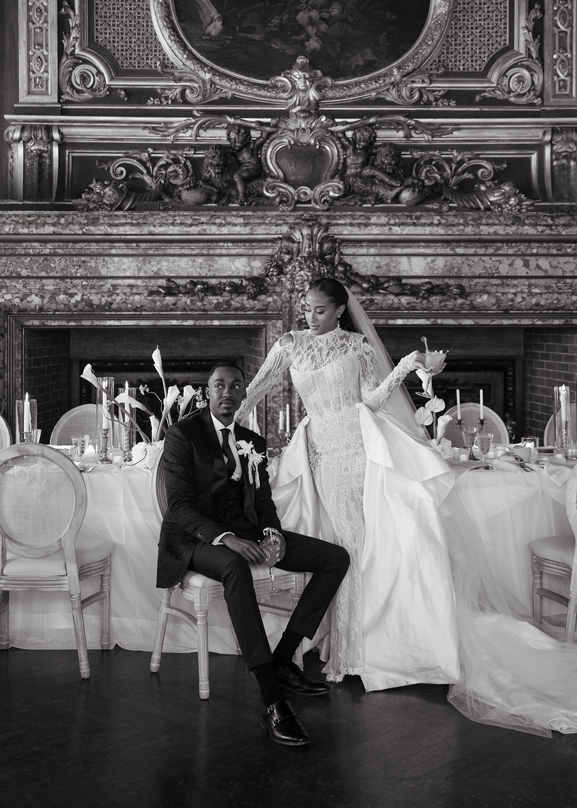 Bride and groom sitting together at a lavish table with floral arrangements during their Brunch Wedding at Ochre Court Newport.

