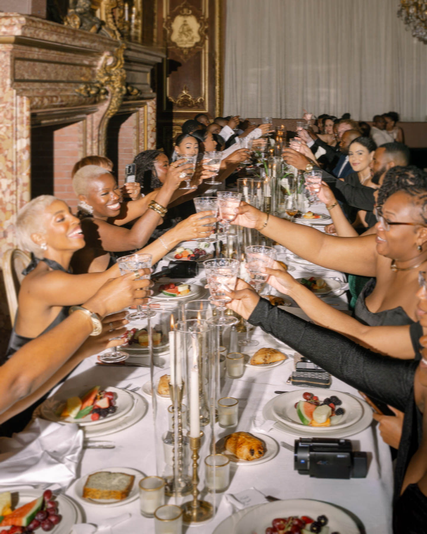 Guests celebrating with cheers during the reception at the brunch wedding at Ochre Court Newport, raising their glasses in a joyful toast.