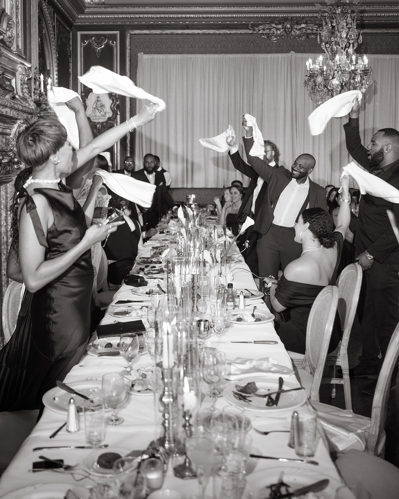 Guests celebrating during the reception at the brunch wedding at Ochre Court Newport, waving napkins joyfully as part of the lively atmosphere.