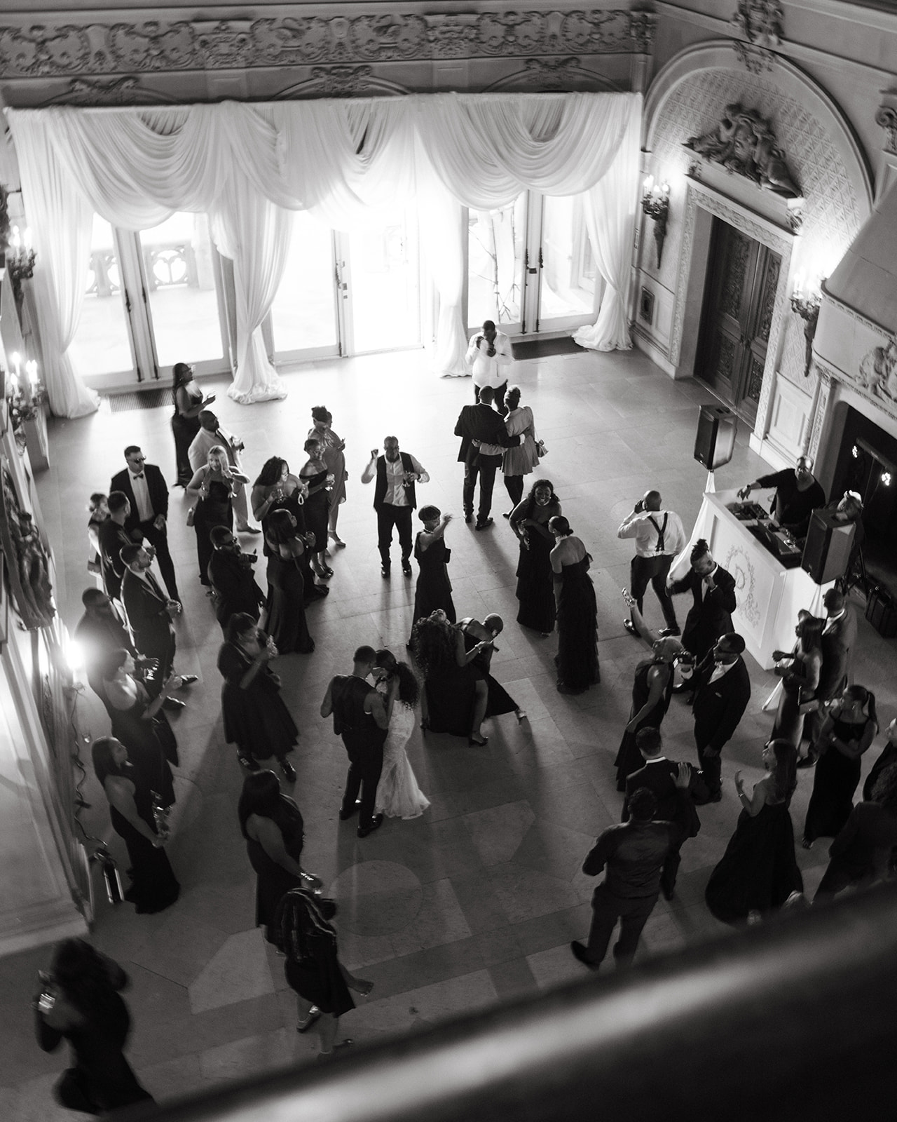 A panoramic view of wedding guests dancing on the floor during the brunch wedding reception at Ochre Court Newport, captured from above in a romantic black-and-white shot.