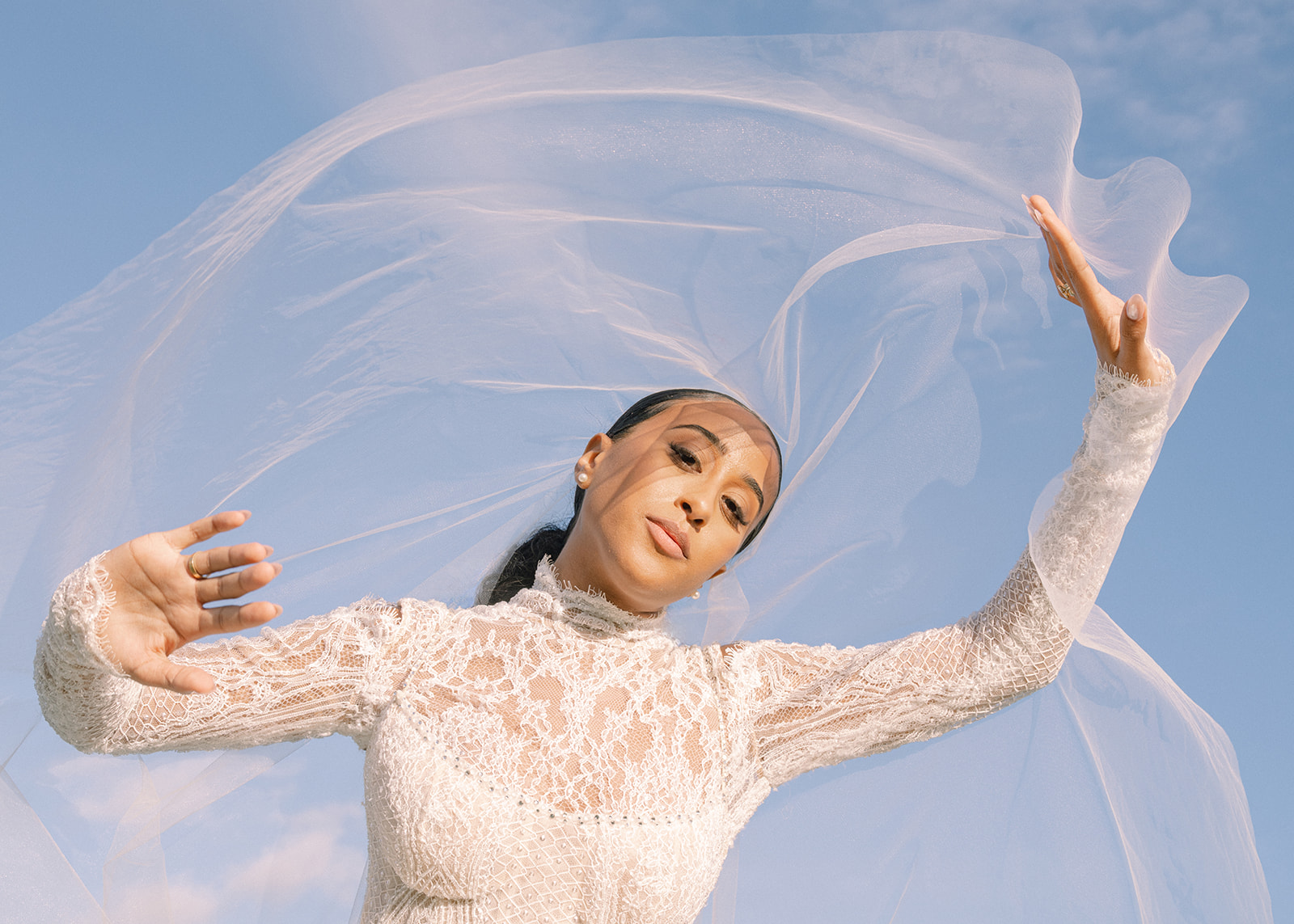 A serene moment captured at the Brunch Wedding at Ochre Court Newport, with the bride's veil gracefully flowing in the wind.