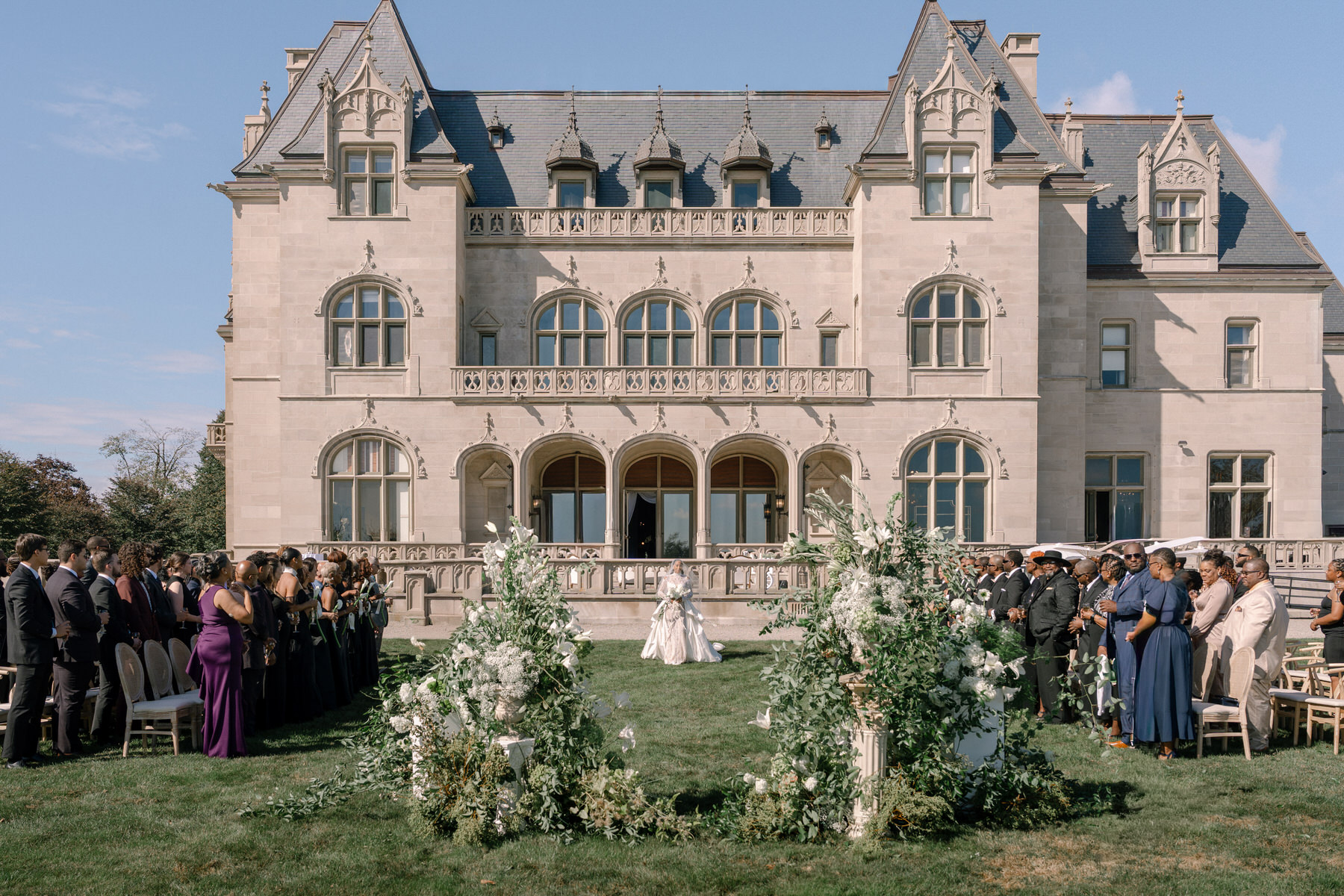Wedding ceremony at Ochre Court Newport with stunning floral arrangements and guests gathered in the scenic outdoor space for a brunch wedding celebration.