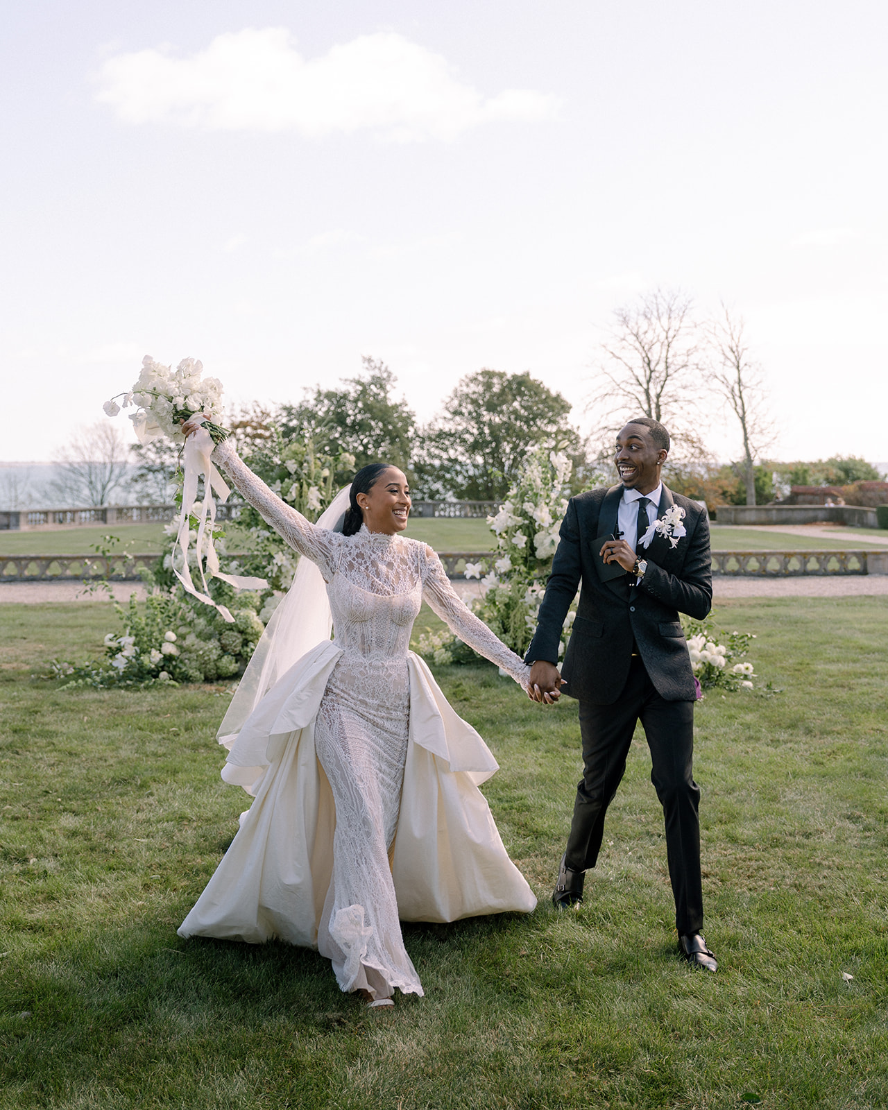 Bride and groom celebrating their newlywed status during the Brunch Wedding at Ochre Court Newport, walking hand-in-hand with joy.
